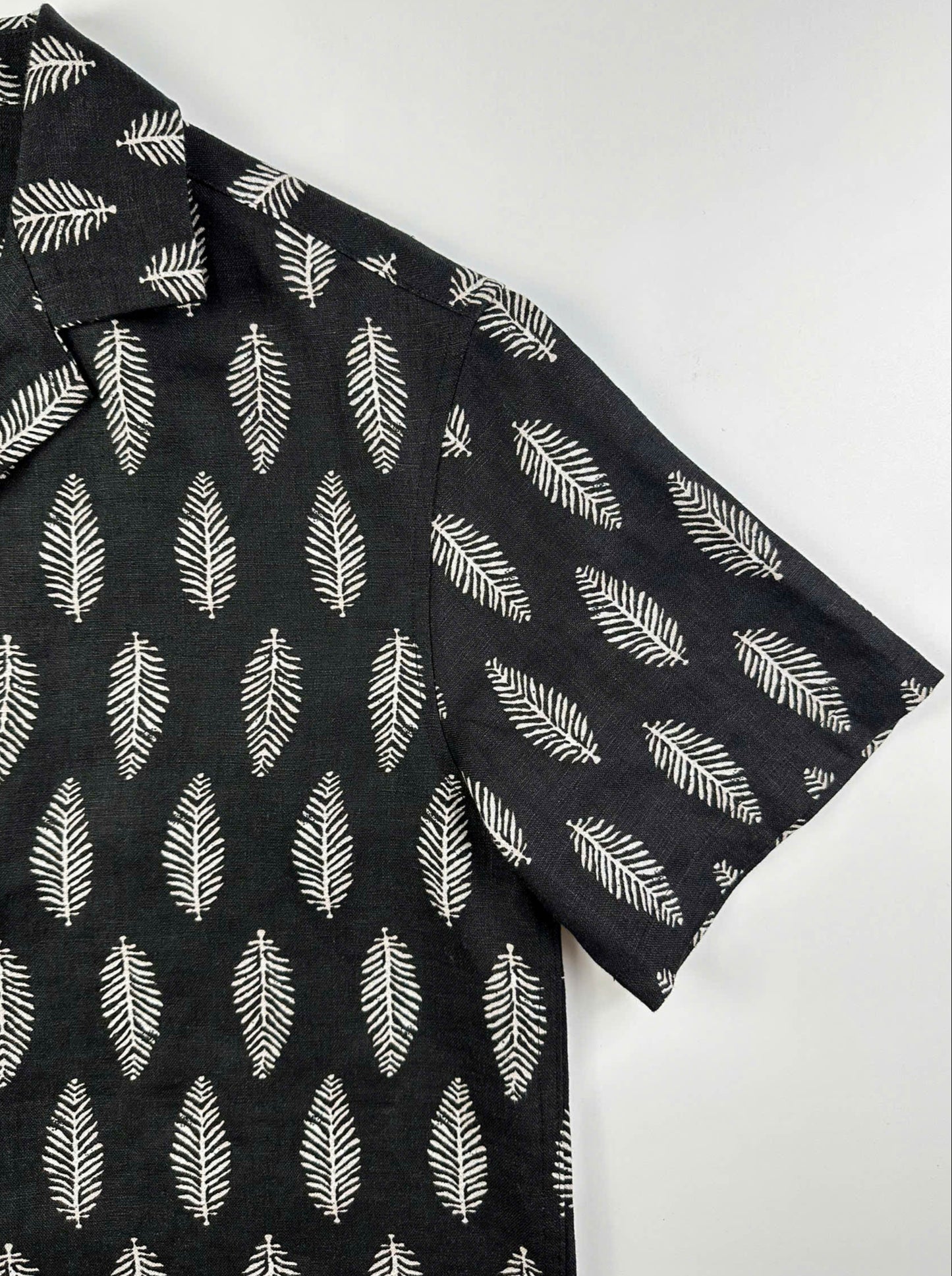Sleeve detail - close up of silver fern pattern on black premium linen fabric