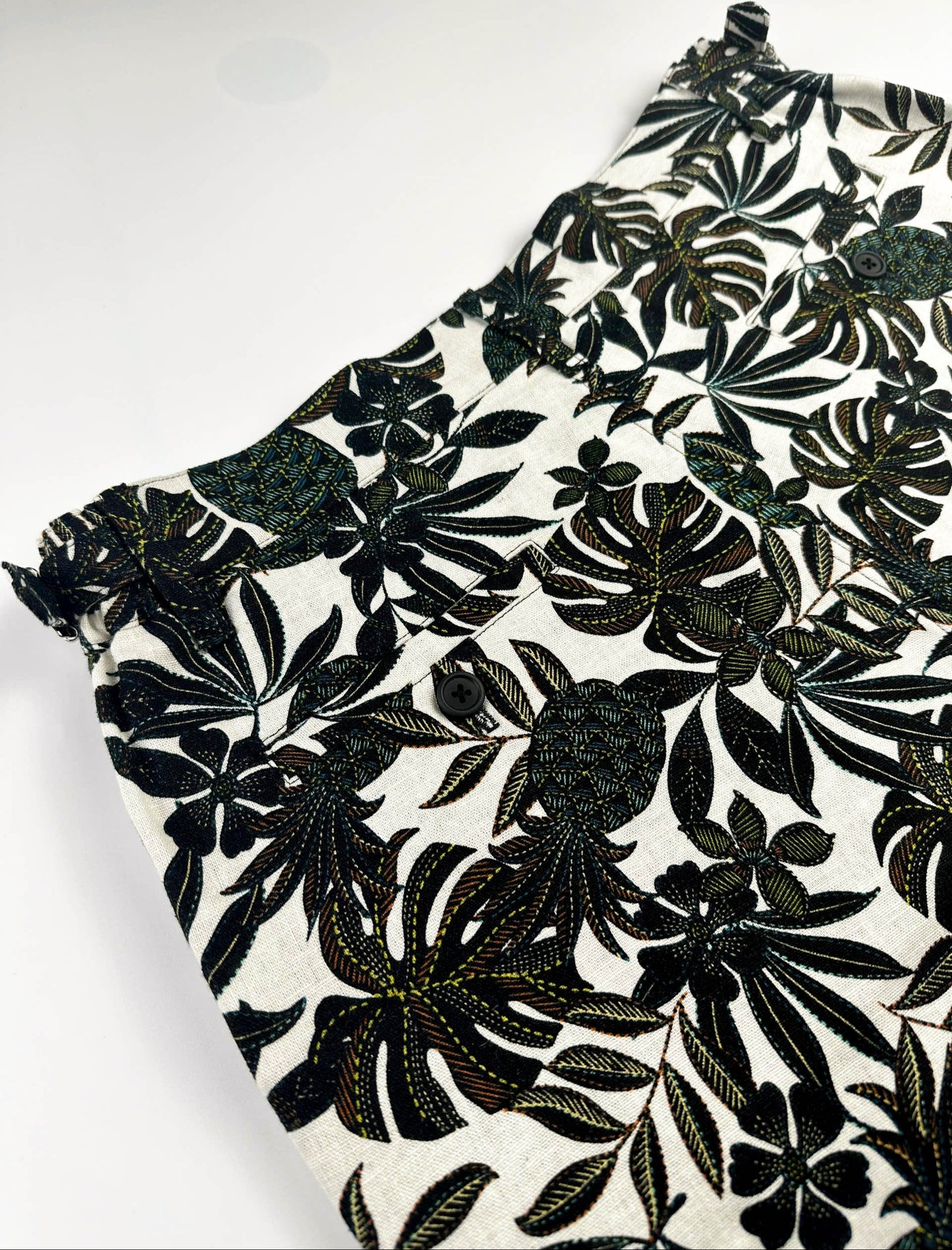 Back waist detail - black tropical floral patterned linen shorts on a natural white background