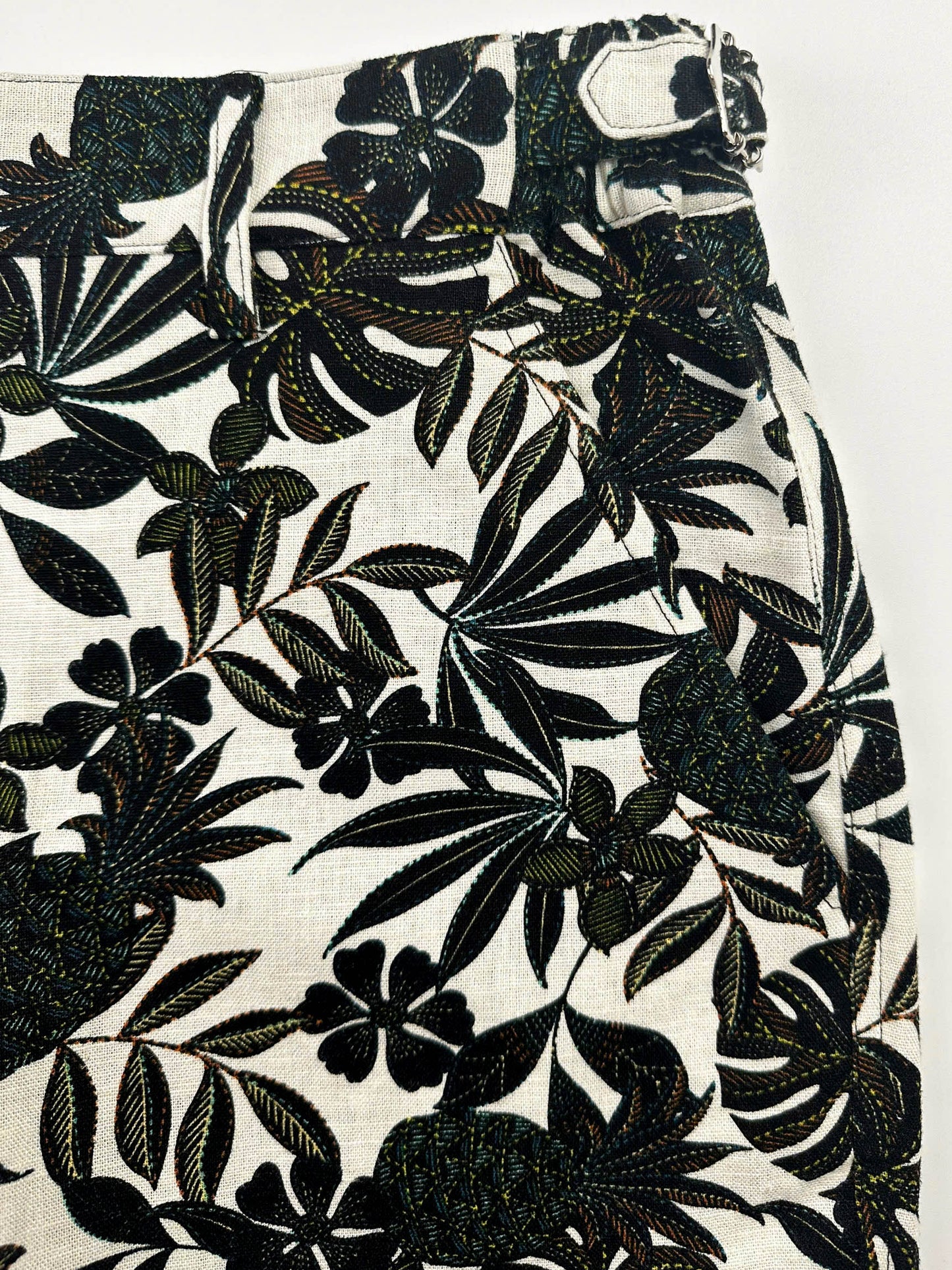 Pocket detail - Black tropical floral patterned linen shorts on a natural white background