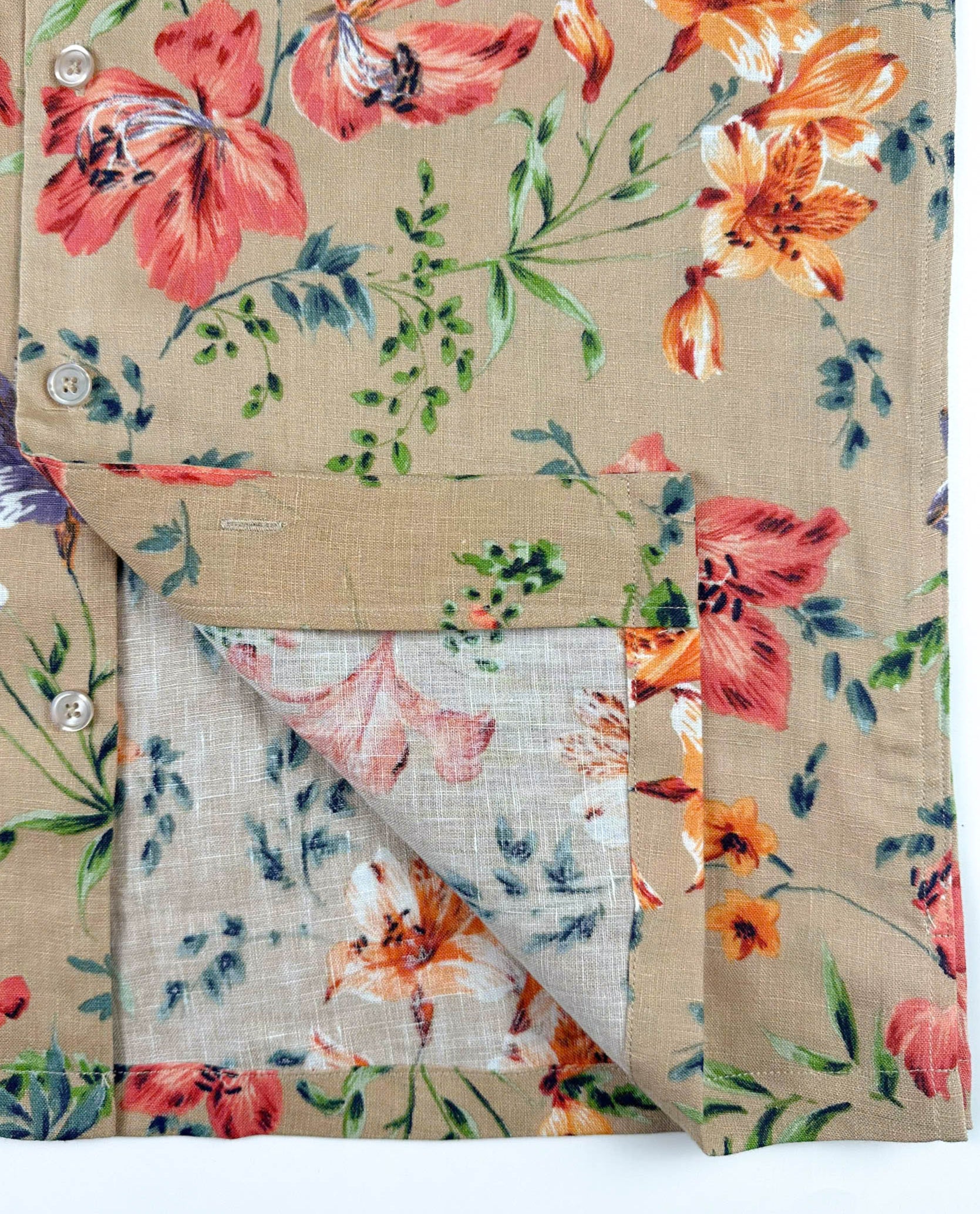 Fabric finish detail - Vibrant Floral patterned linen Hawaiian style shirt on a sandy beige background