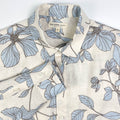 Blue Hibiscus linen long sleeve button-up shirt lay flat neck view, light blue hibiscus print on natural white linen