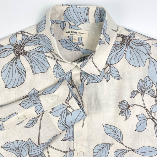Blue Hibiscus linen long sleeve button-up shirt lay flat neck view, light blue hibiscus print on natural white linen