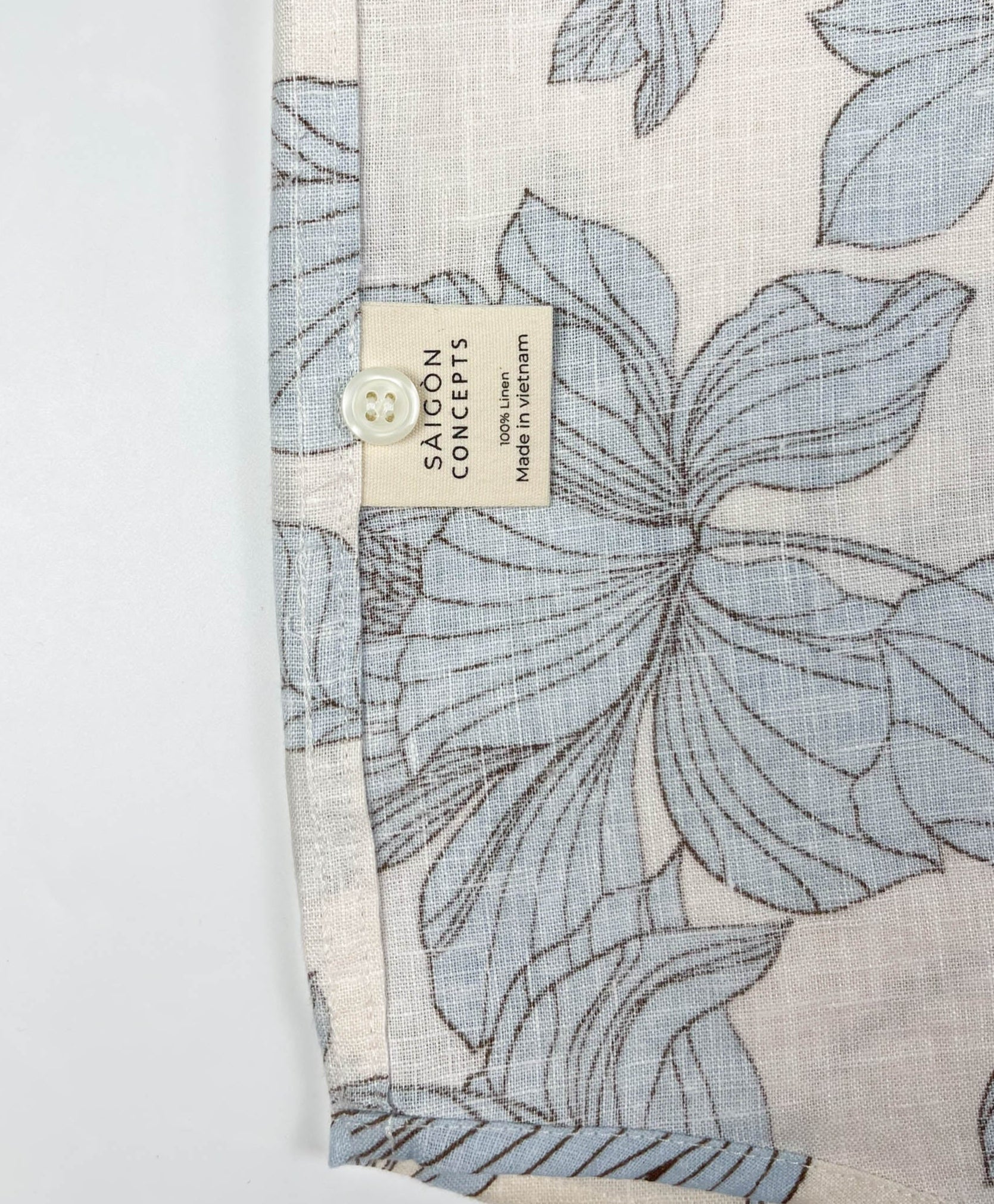 Blue Hibiscus linen long sleeve button-up shirt lay flat care label view