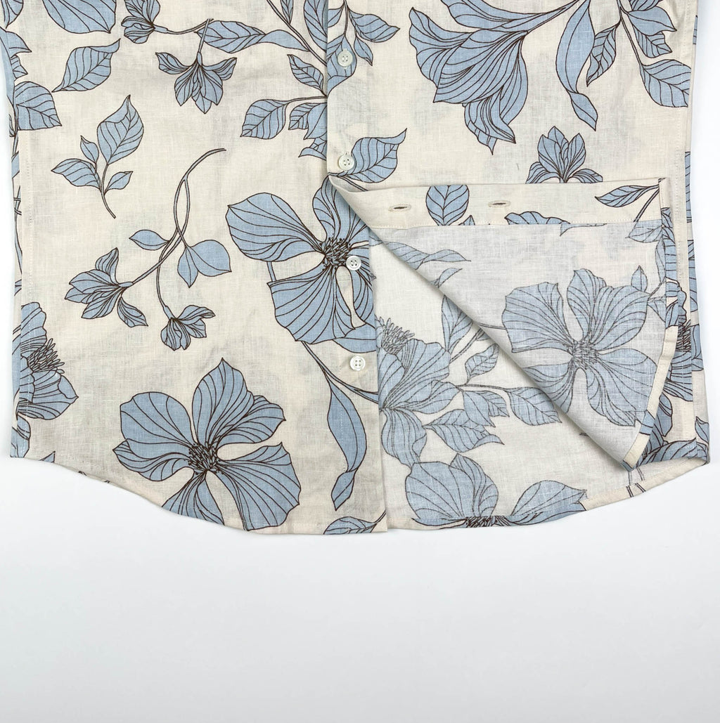 Blue Hibiscus linen long sleeve button-up shirt lay flat inside seam view, light blue hibiscus print on natural white linen