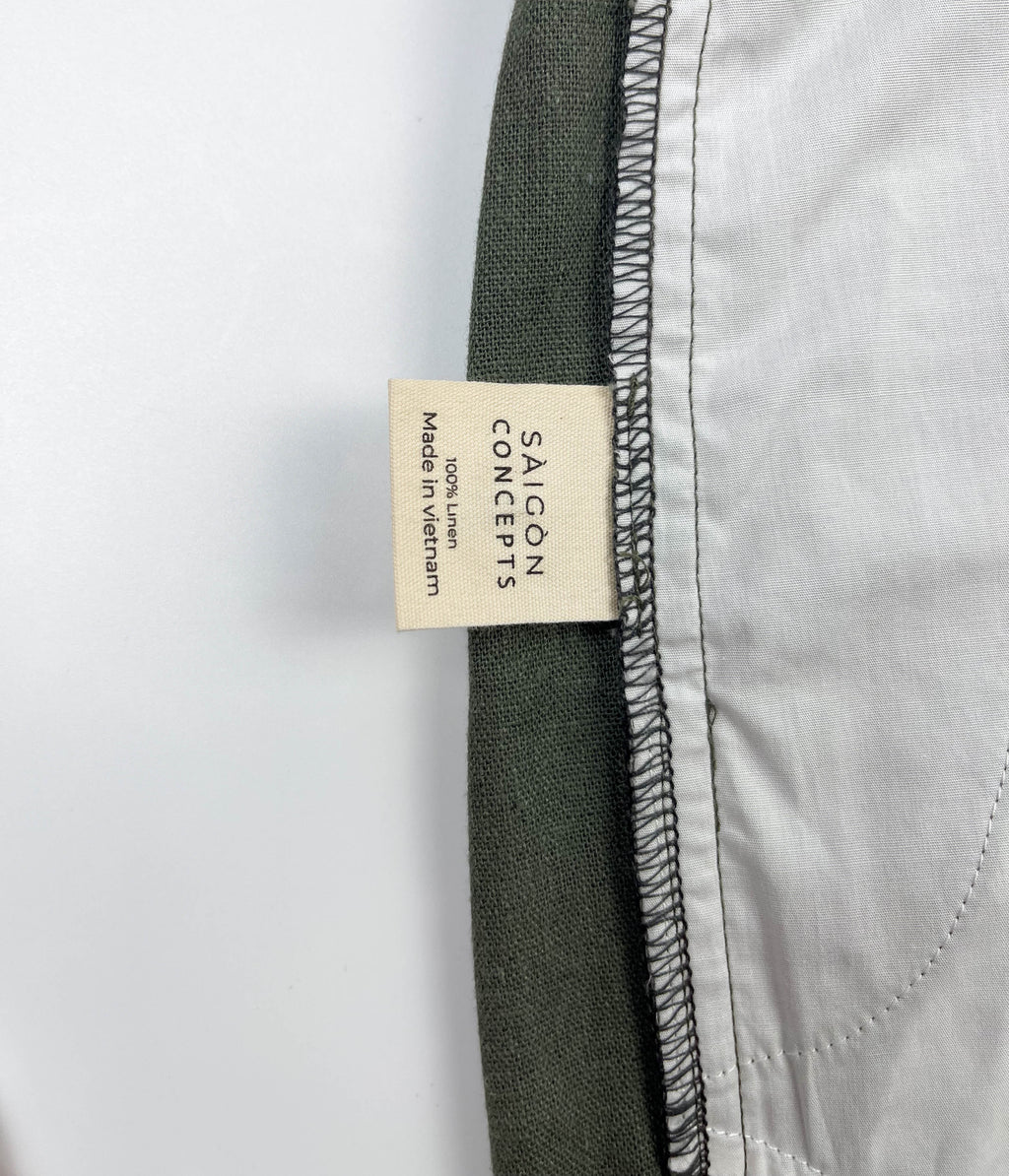 Inside care label and spare button detail of army green linen Riviera shorts - Saigon Concepts