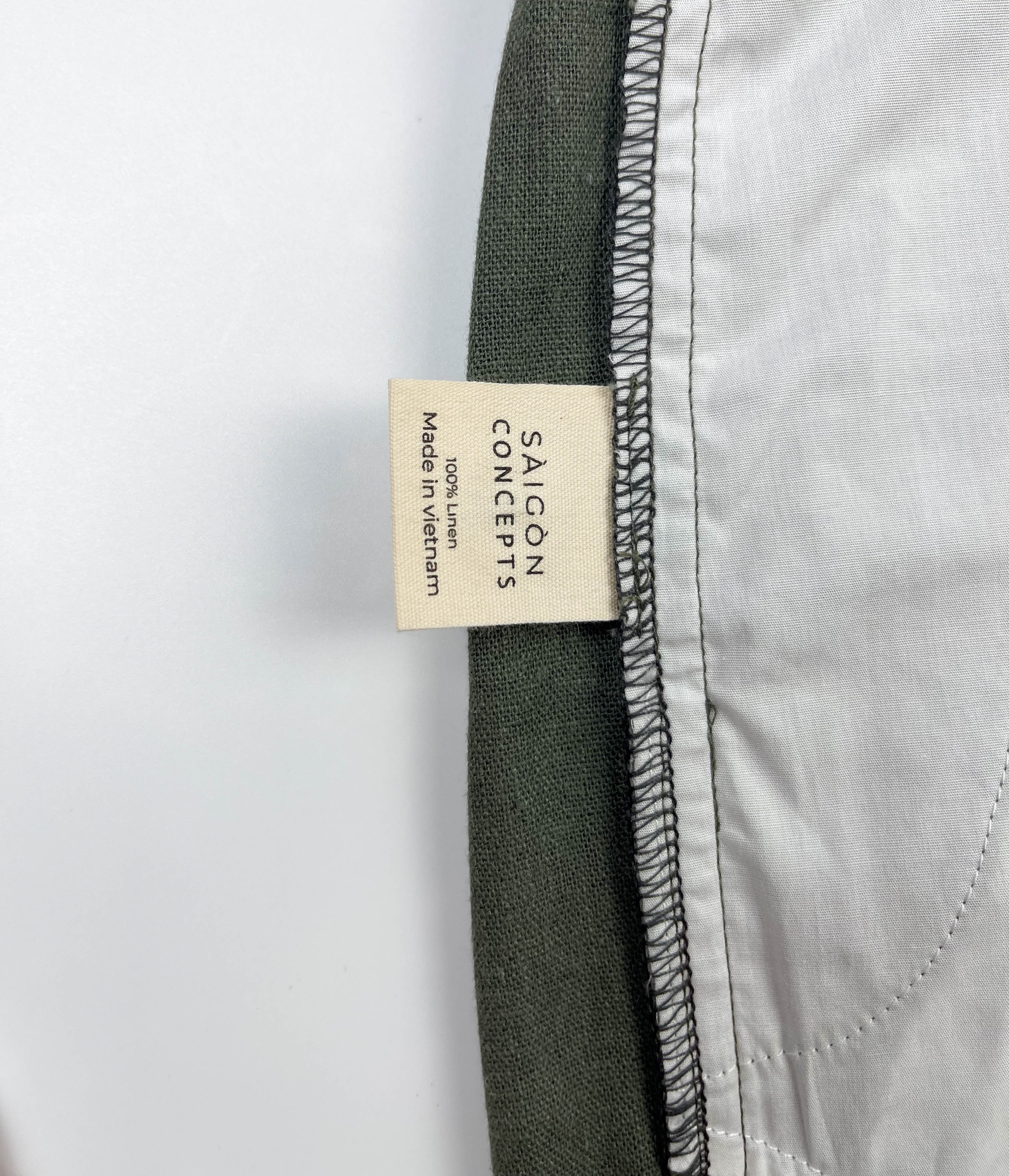 Inside care label and spare button detail of army green linen Riviera shorts - Saigon Concepts