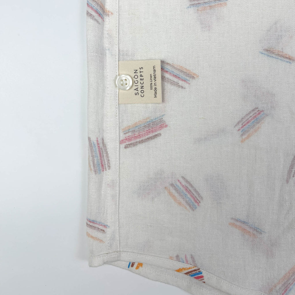 Crayon Strokes on natural white linen fabric, button-up shirt lay flat care label view