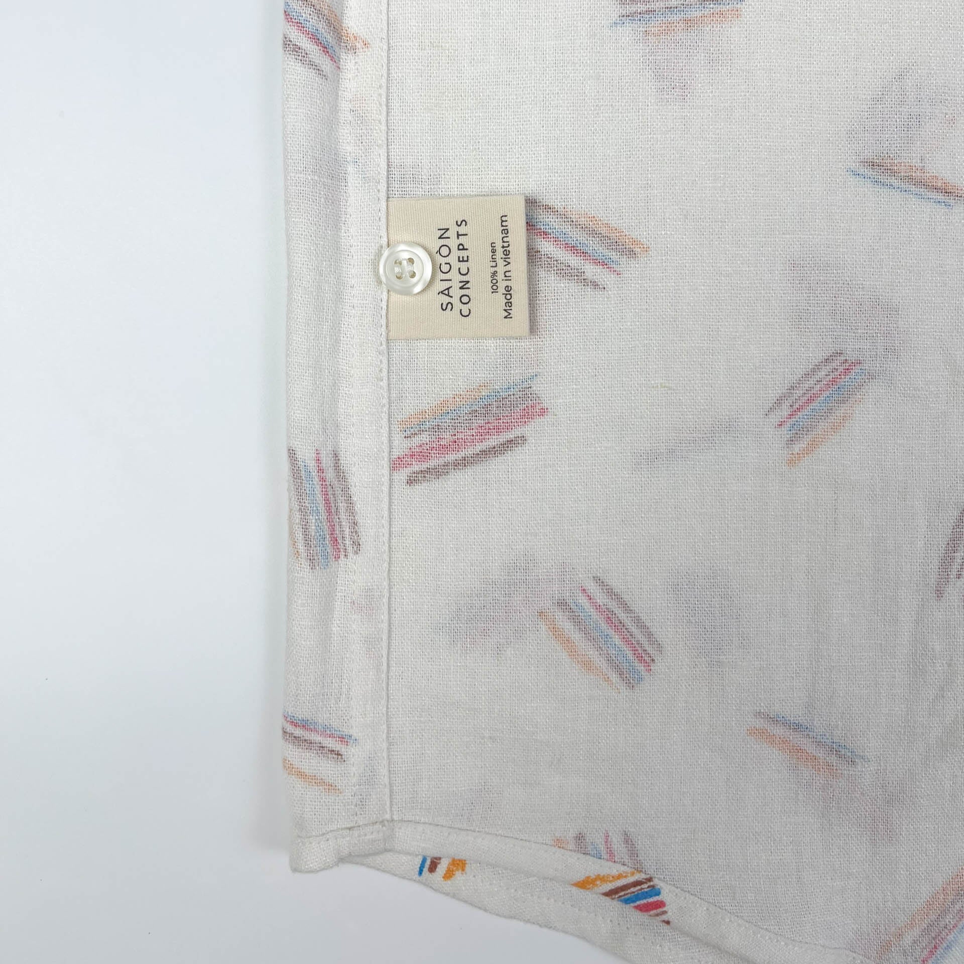 Crayon Strokes on natural white linen fabric, button-up shirt lay flat care label view