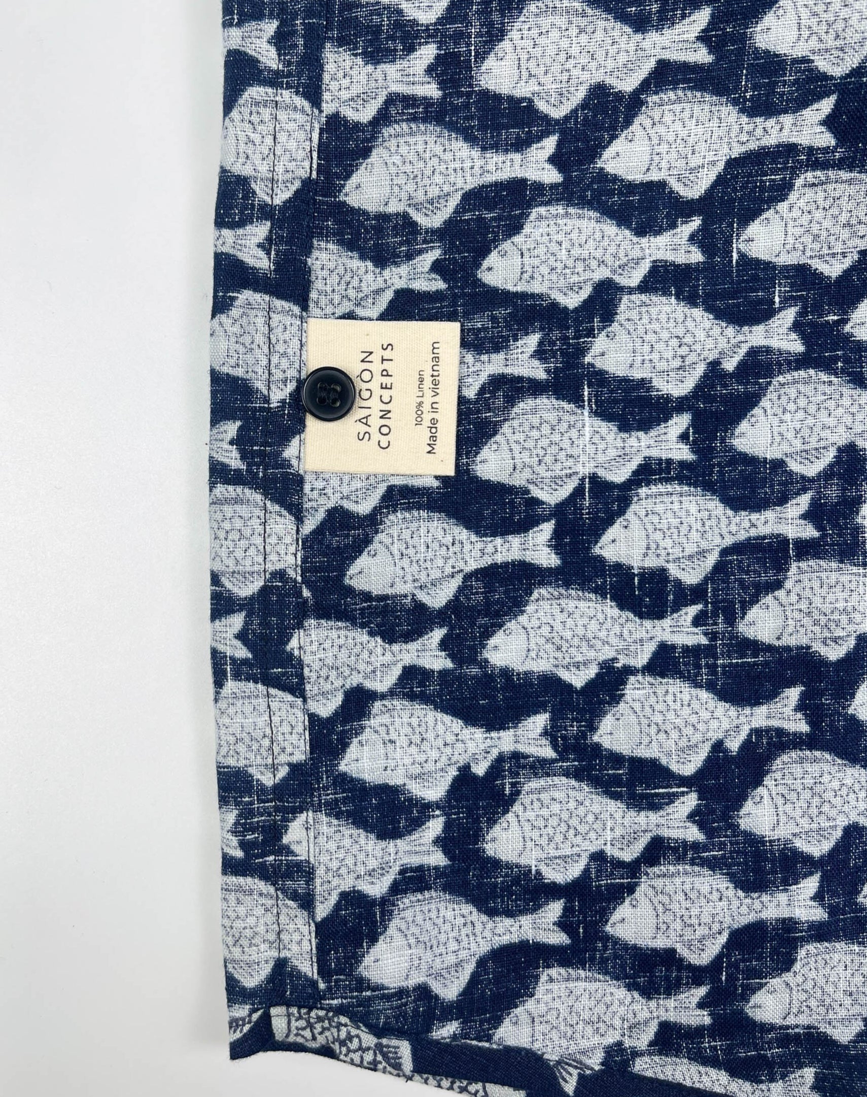 Darkwave Shoal linen short sleeve button-up shirt lay flat care label view, white fish shoal print on navy