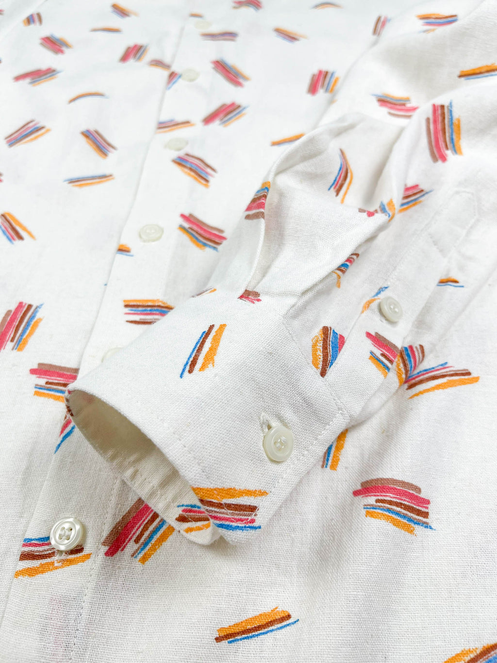 Crayon Strokes linen long sleeve button-up shirt with colourful crayon stroke print on natural white fabric - lay flat cuff detail view