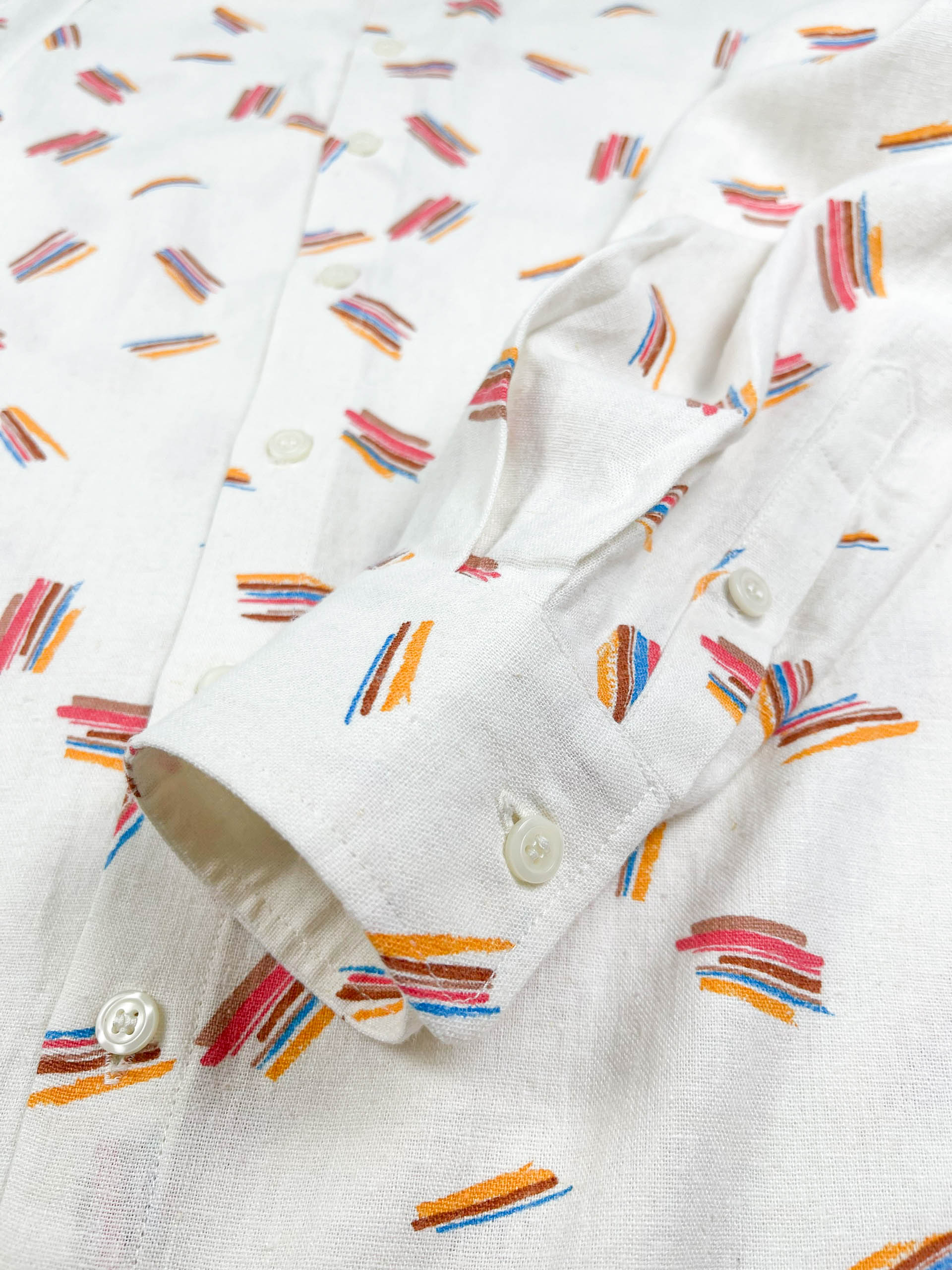 Crayon Strokes linen long sleeve button-up shirt with colourful crayon stroke print on natural white fabric - lay flat cuff detail view