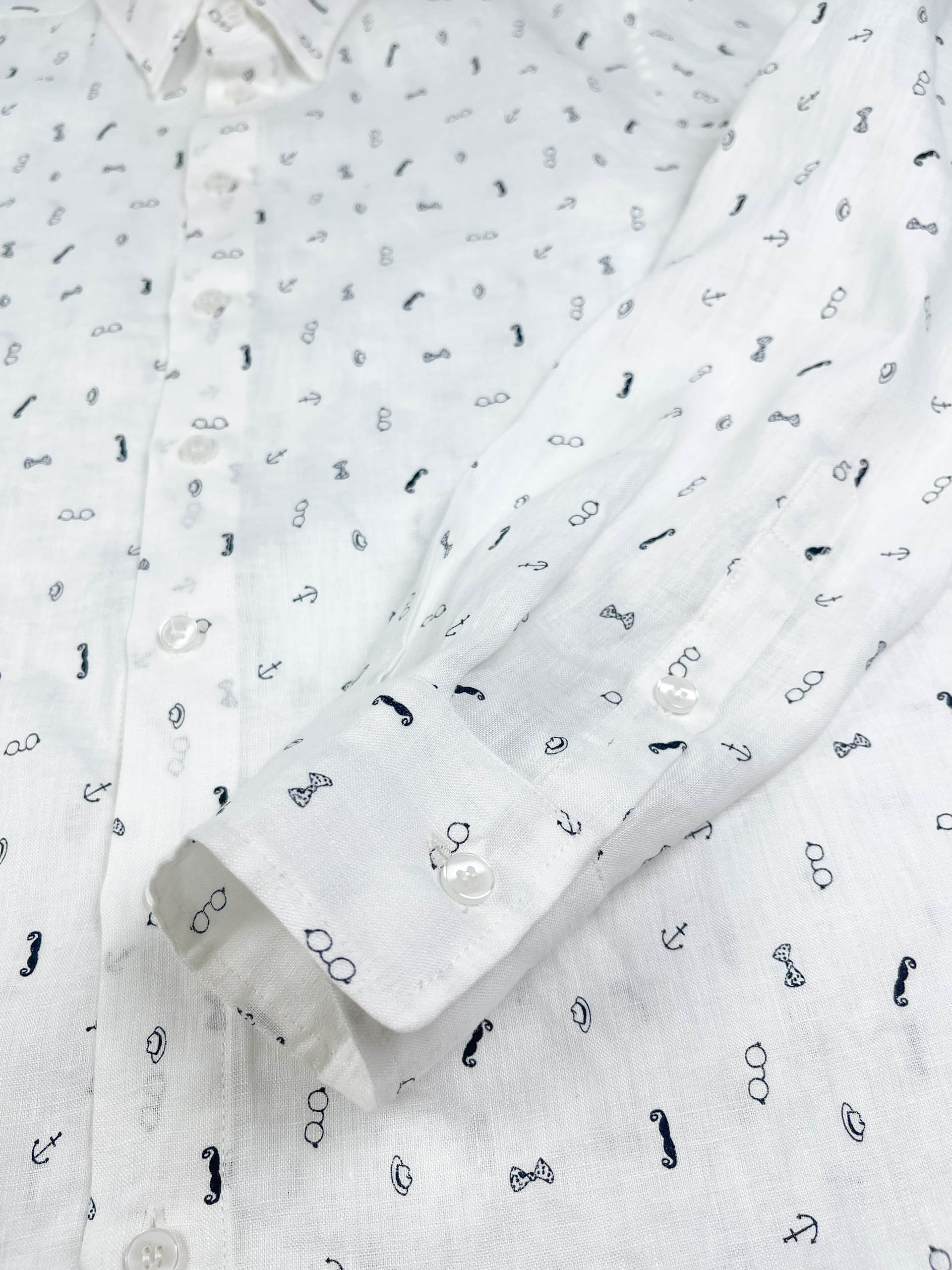 Gentlemen Club linen long sleeve button-up shirt lay flat cuff detail view, minimalist print on white linen