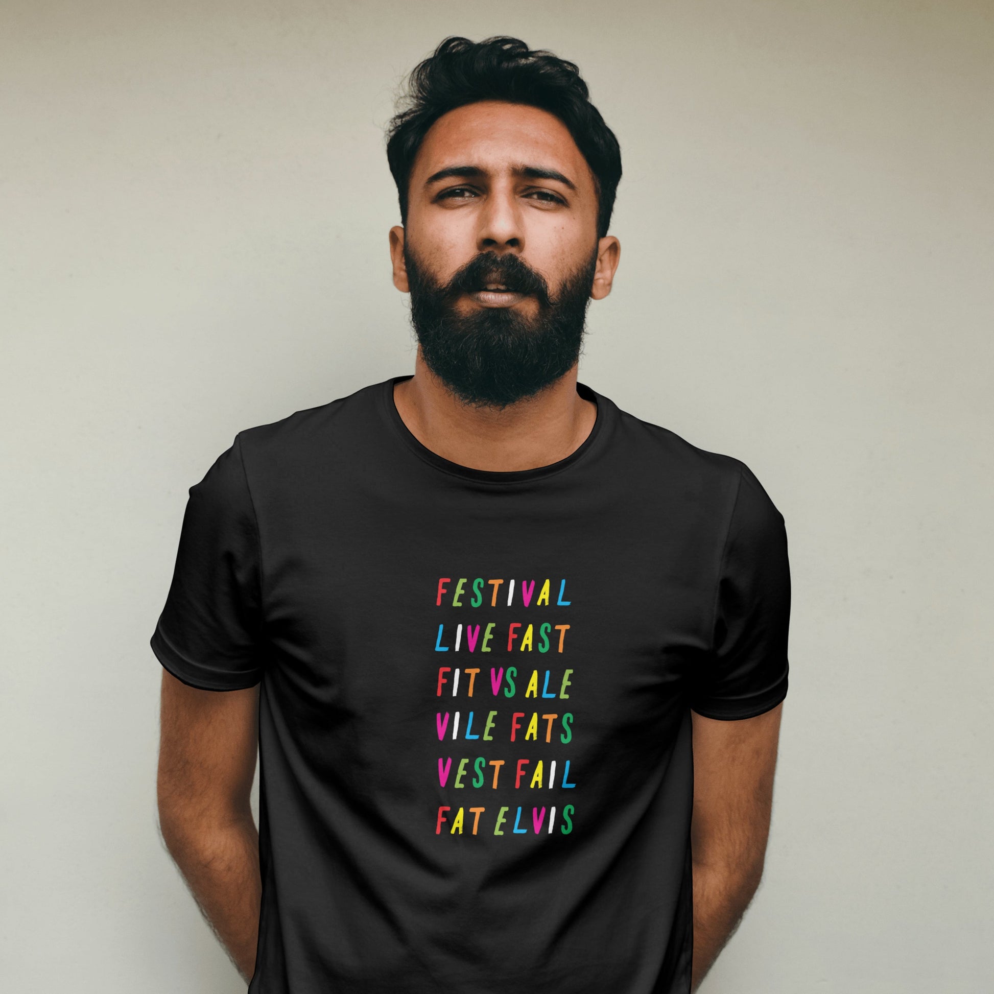 Man wearing a black t-shirt with rainbow coloured text against a plain background