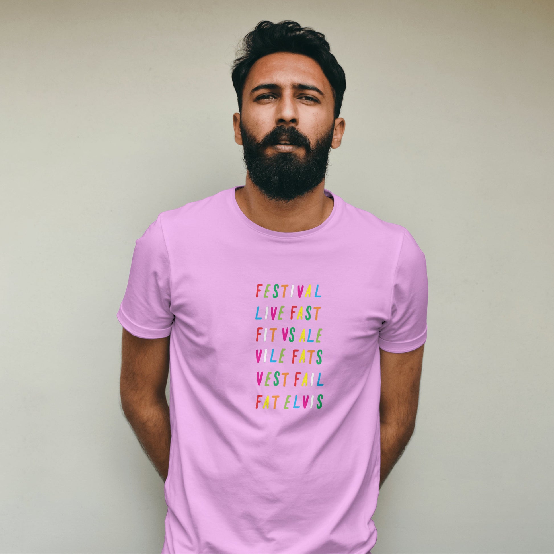 Man wearing a pink t-shirt with rainbow coloured text against a plain background
