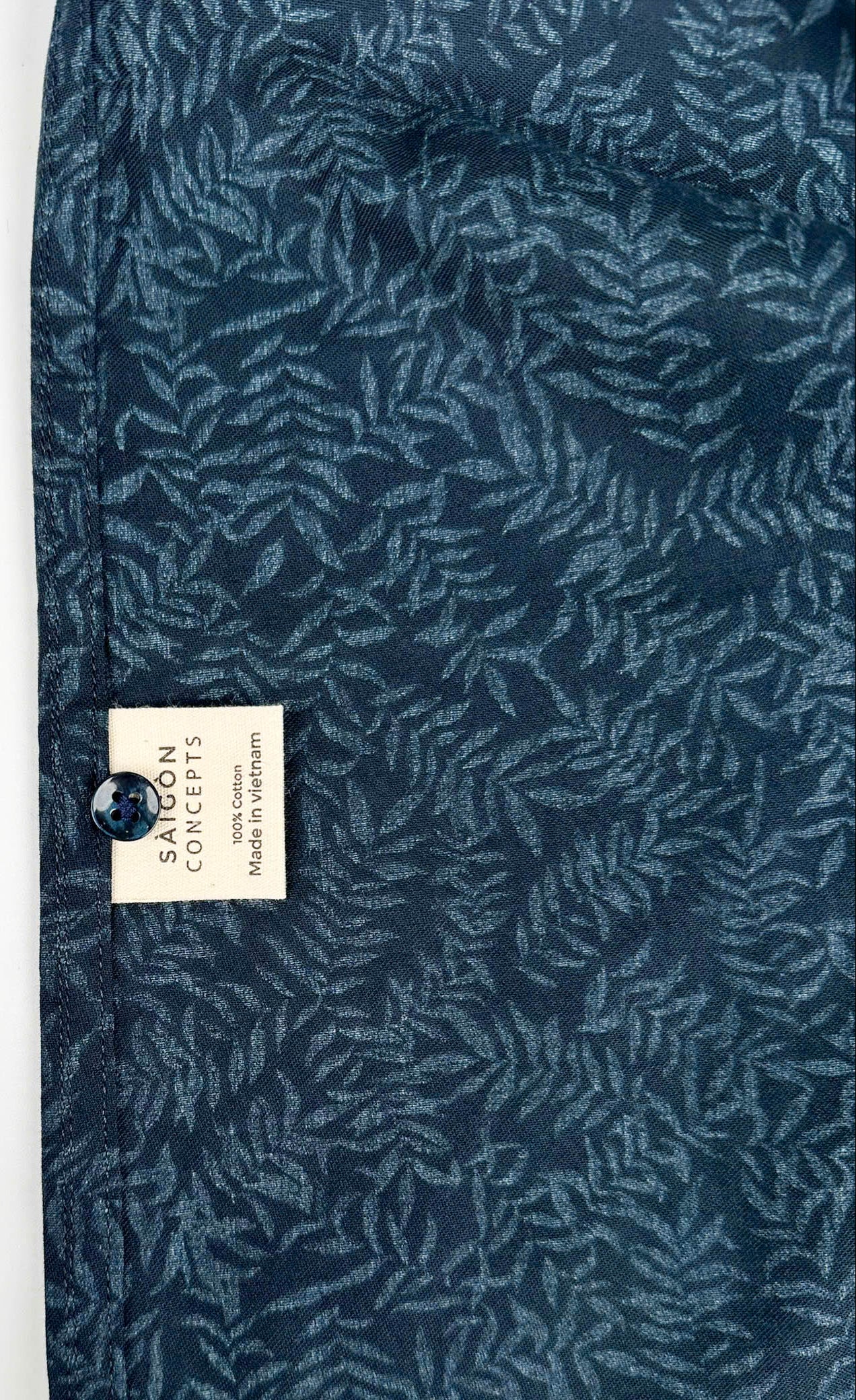 Mossy Leaf cotton short sleeve button-up shirt, teal blue leaf print on navy, inside care label view