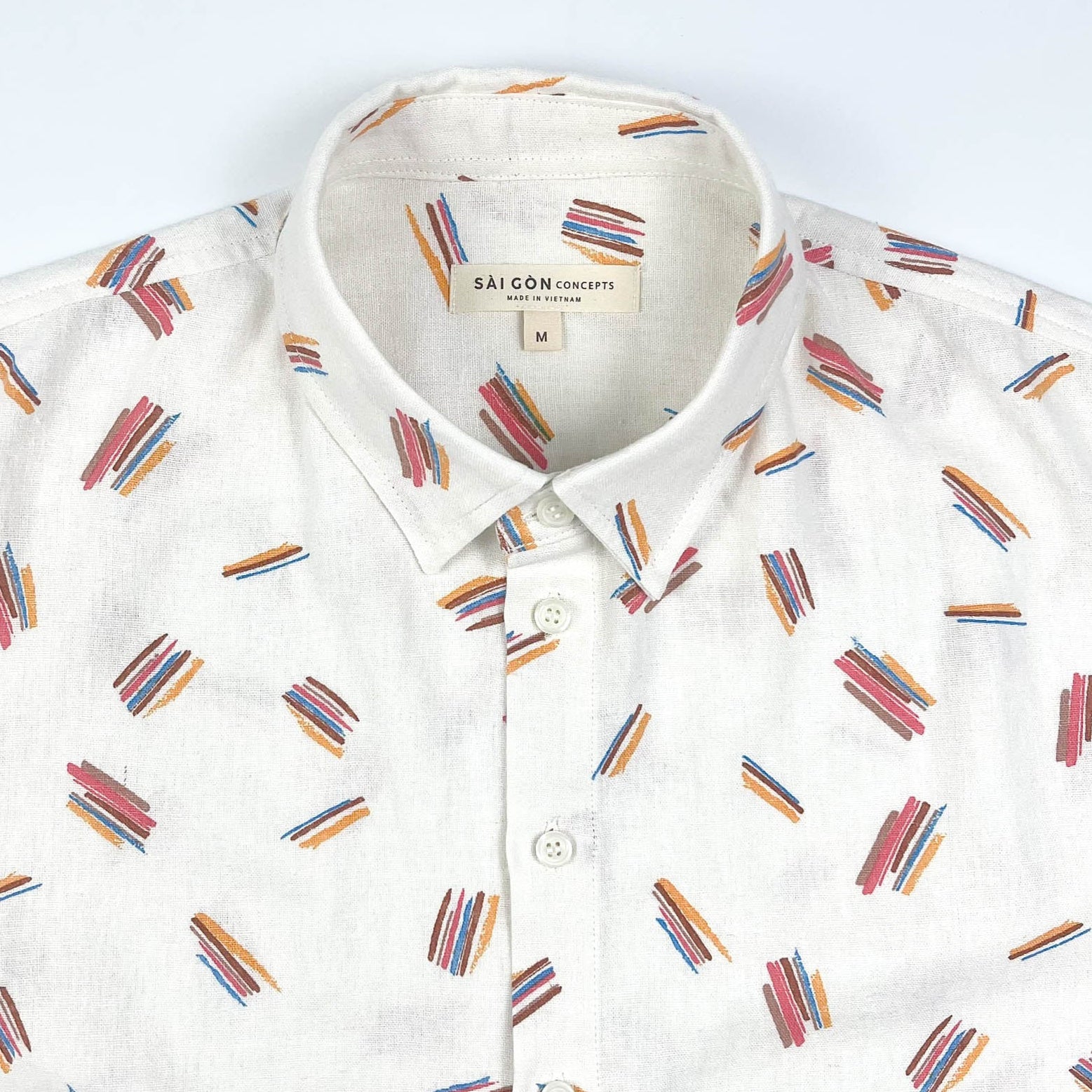 Crayon Strokes on natural white linen fabric, short sleeve button-up shirt lay flat neck detail view