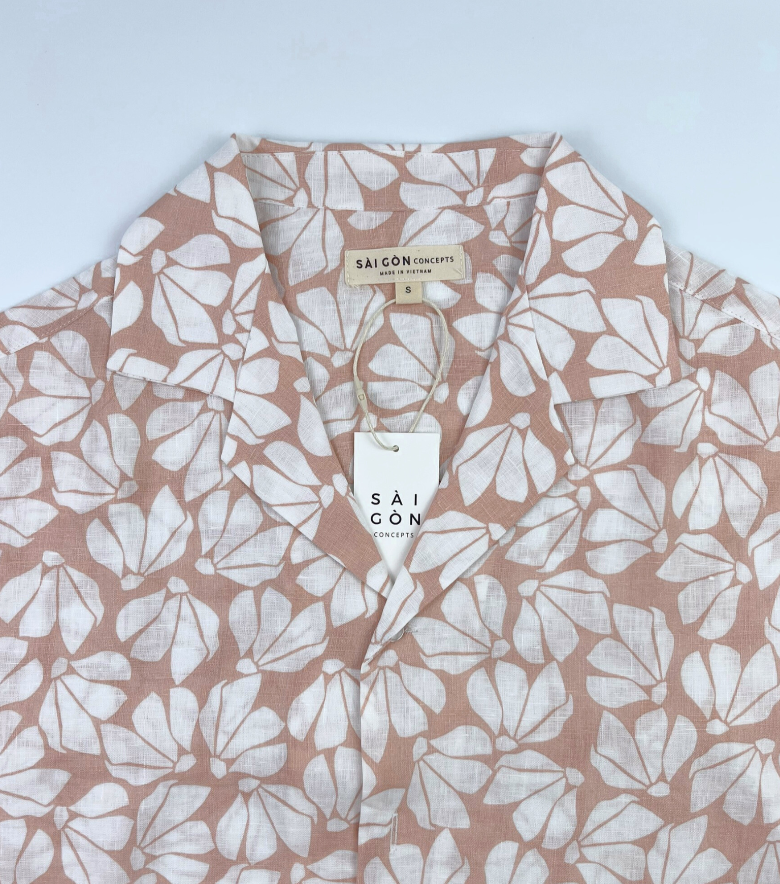 Close-up of white floral print on pink linen fabric, breathable natural fiber Hawaii shirt