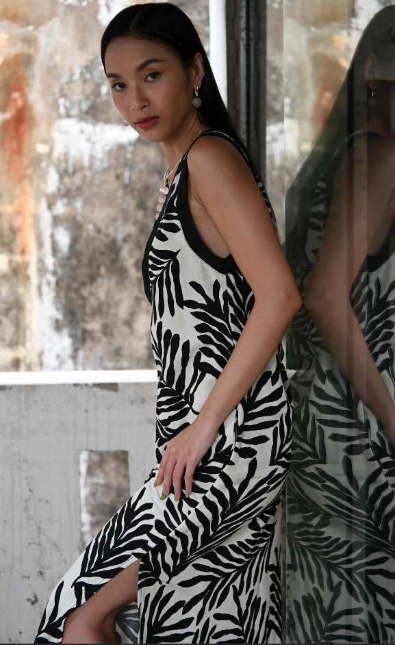 Woman wearing a black and white patterned dress in an indoor setting.