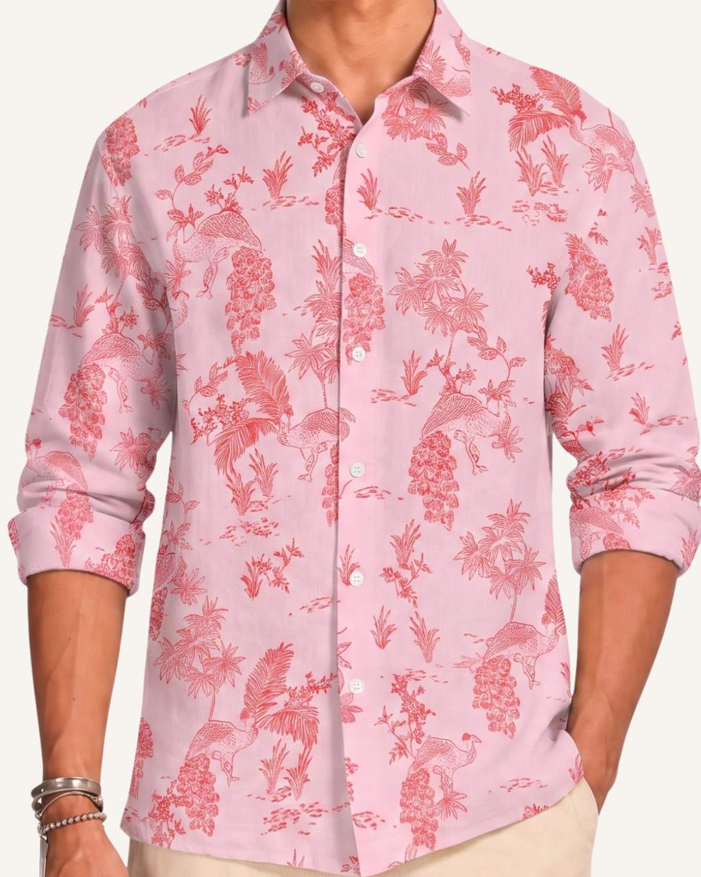 A man wearing a light pink long-sleeve button-up shirt with a darker pink tropical leaf pattern, paired with black trousers, shown against a plain light gray background.