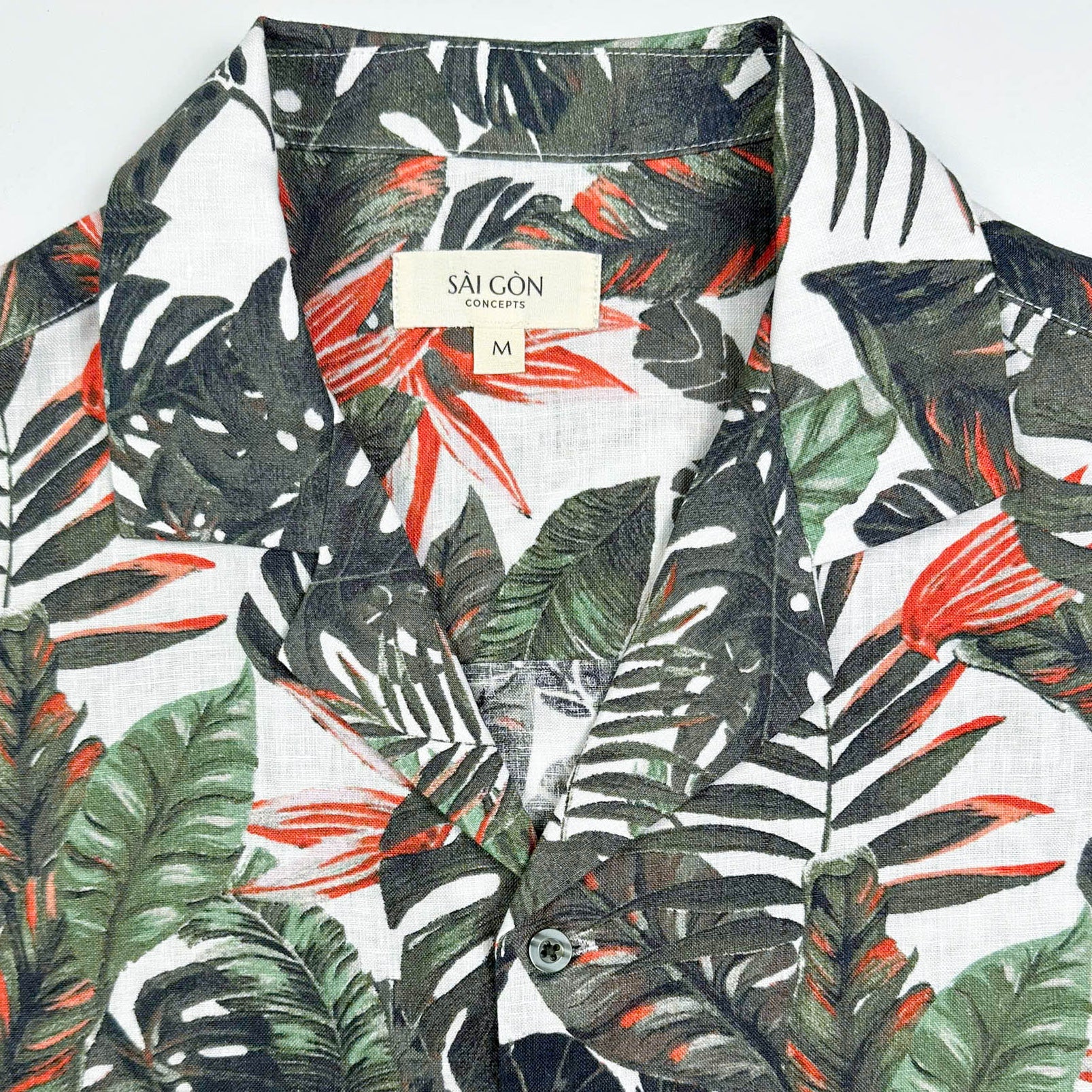 Saigon Concepts Fire & Fern Hawaiian Shirt - tropical jungle print with monstera ferns and bird of paradise florals on natural white linen - front collar detail view