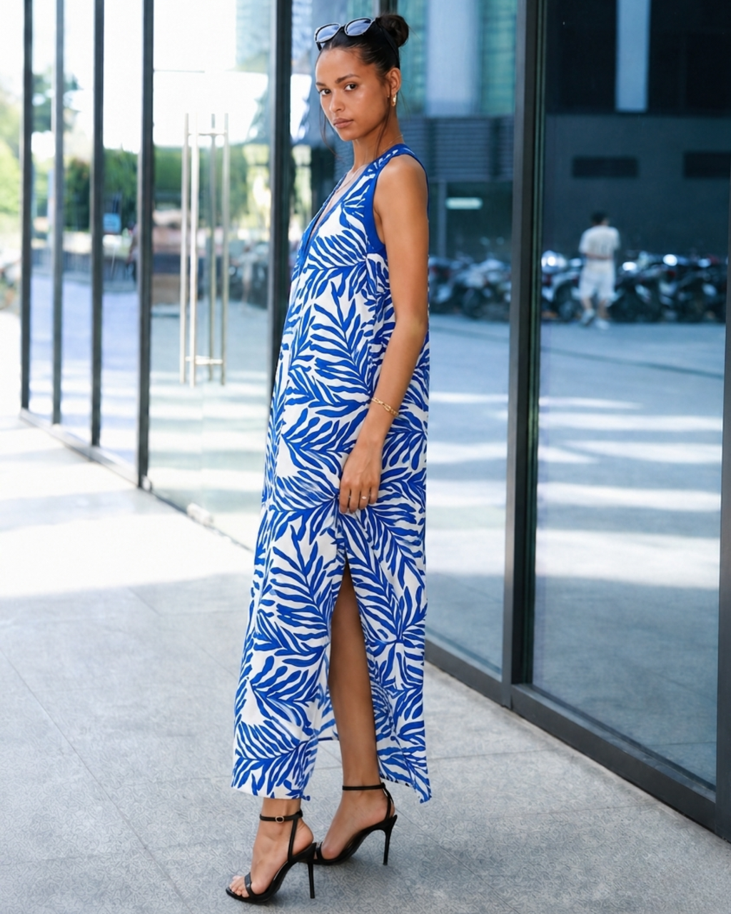 Woman wearing a blue and white patterned maxi dress, side view outdoors
