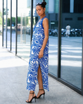 Woman wearing a blue and white patterned maxi dress, side view outdoors