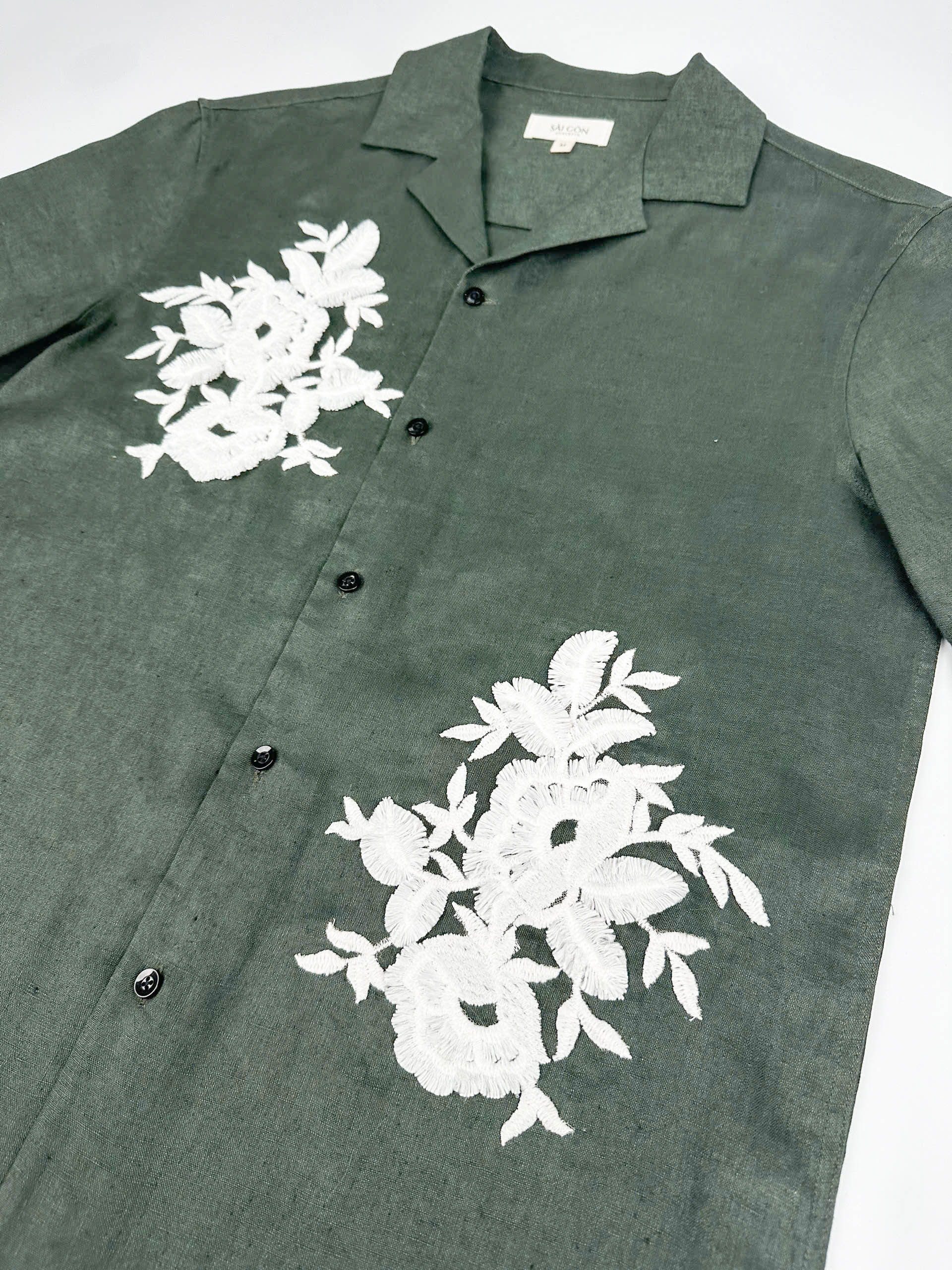 Saigon Concepts Deep Army Green Hawaiian Linen shirt with white floral lace on a light grey background - front side view