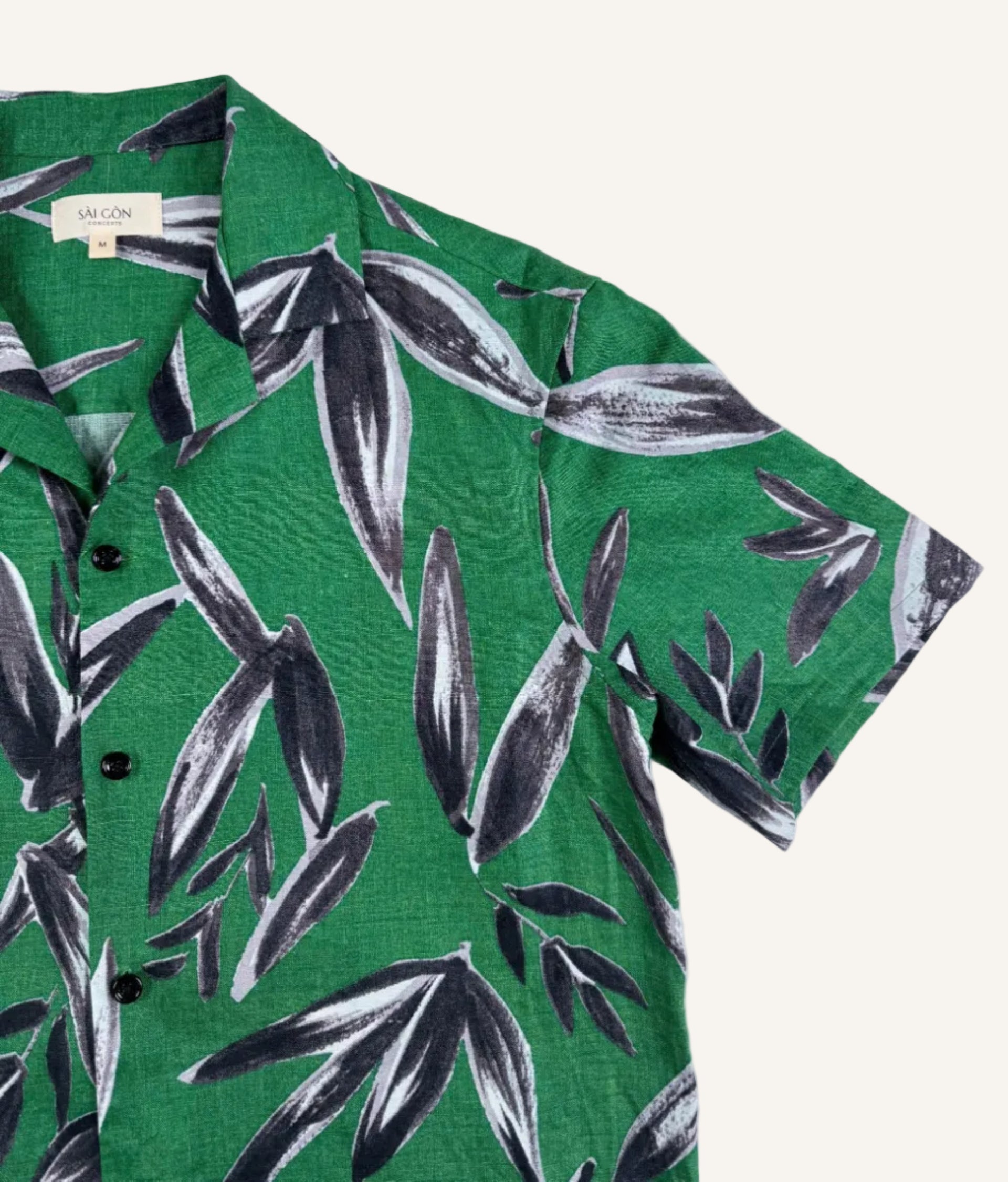 Saigon Concepts Green linen shirt with black leaf pattern on a white background - Collar and sleeve detail view