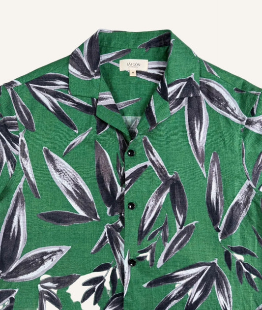 Saigon Concepts Green linen shirt with black leaf pattern on a white background - front neck view
