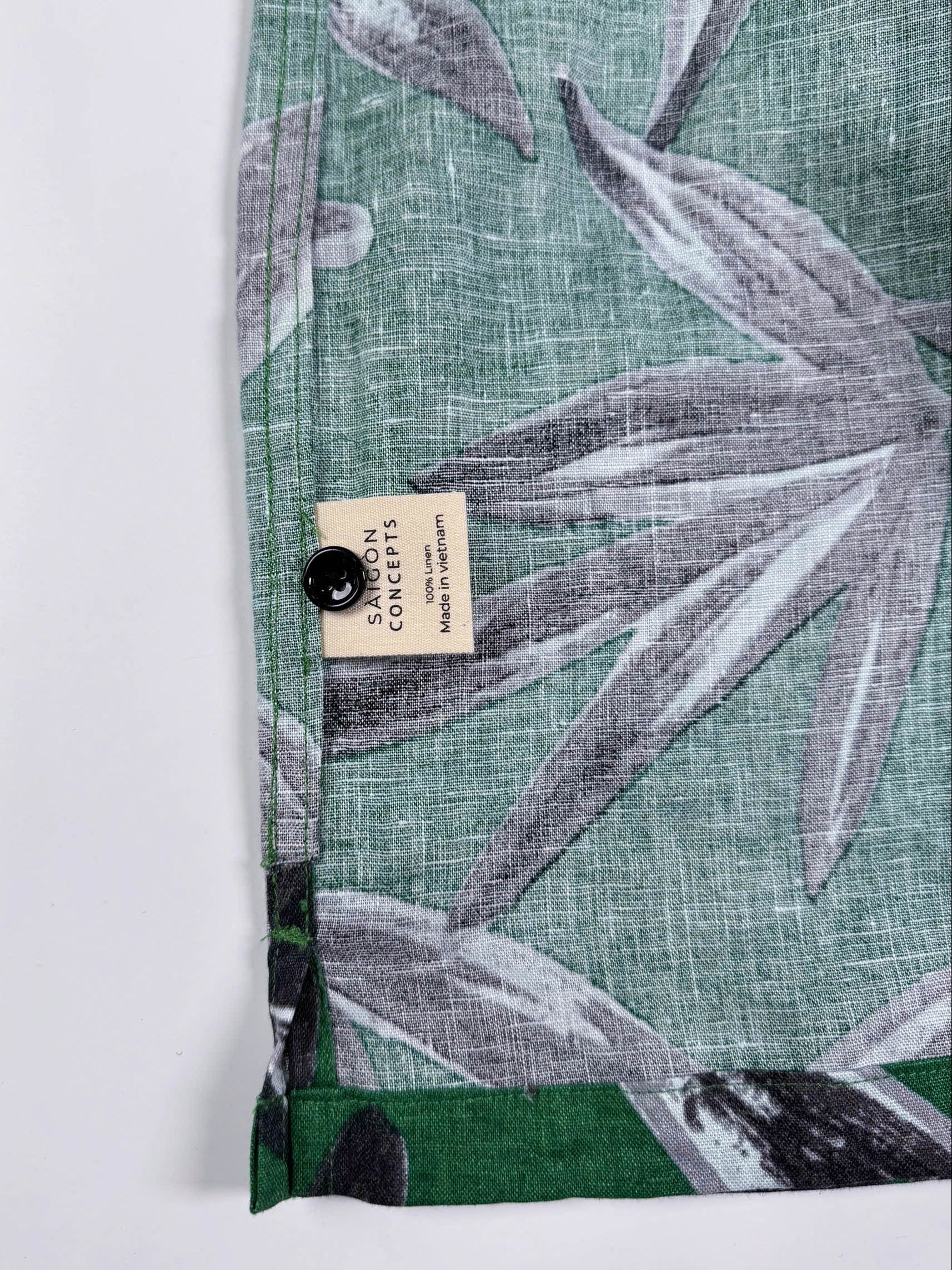 Saigon Concepts Green linen shirt with black leaf pattern on a white background - inside care label view