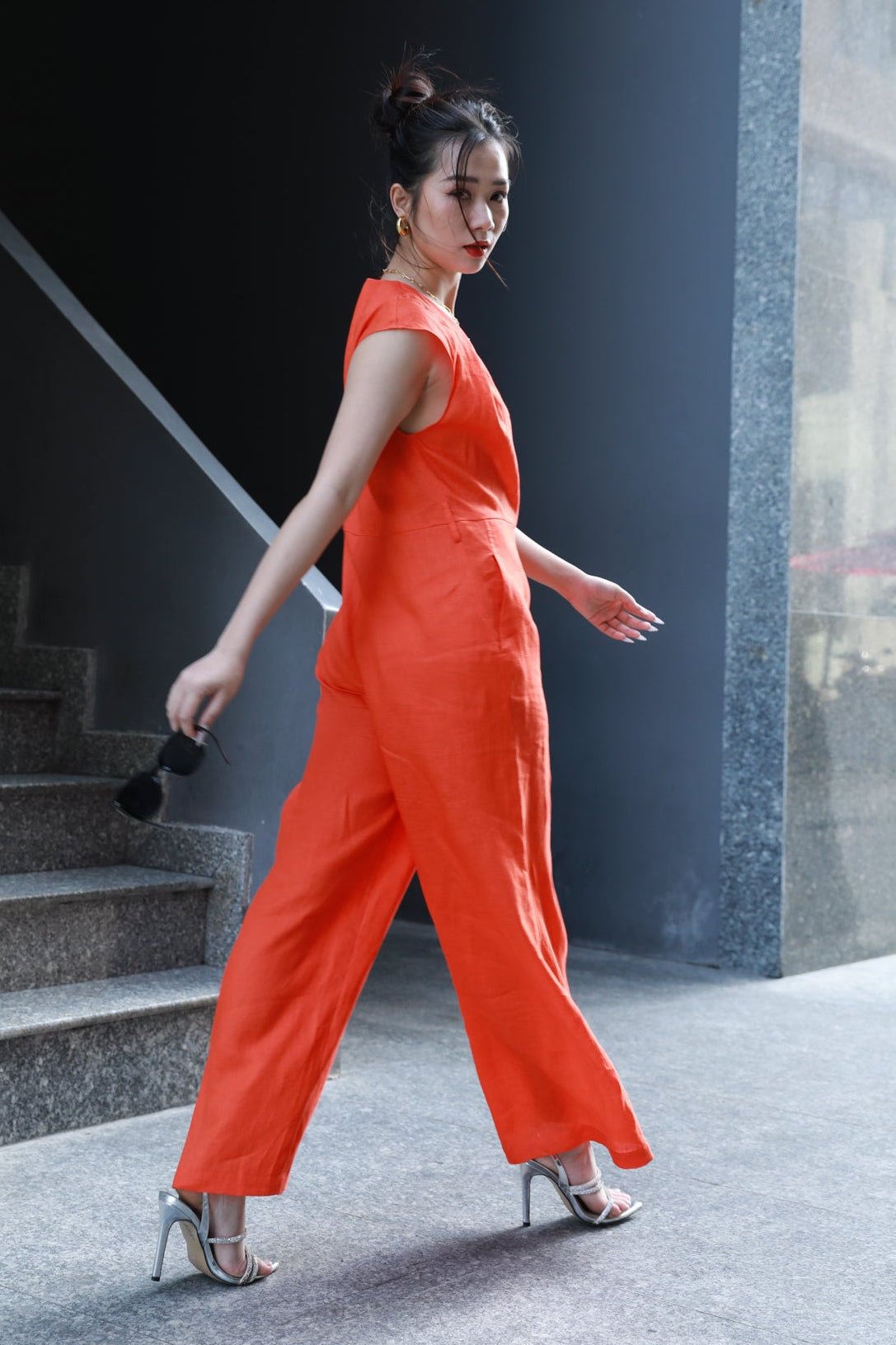 Woman wearing Saigon Concepts Orange Linen Jumpsuit full side and back view