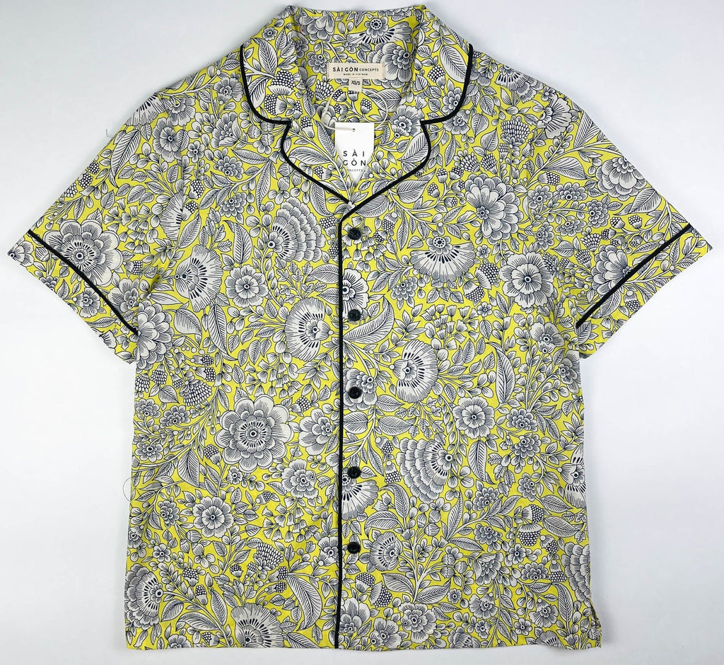 Sunshine Chintz short sleeve pyjama top lay flat, yellow cotton with grey floral print with black contrast piping on sleeves, collar and front. Saigon Concepts