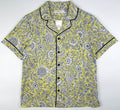 Sunshine Chintz short sleeve pyjama top lay flat, yellow cotton with grey floral print with black contrast piping on sleeves, collar and front. Saigon Concepts