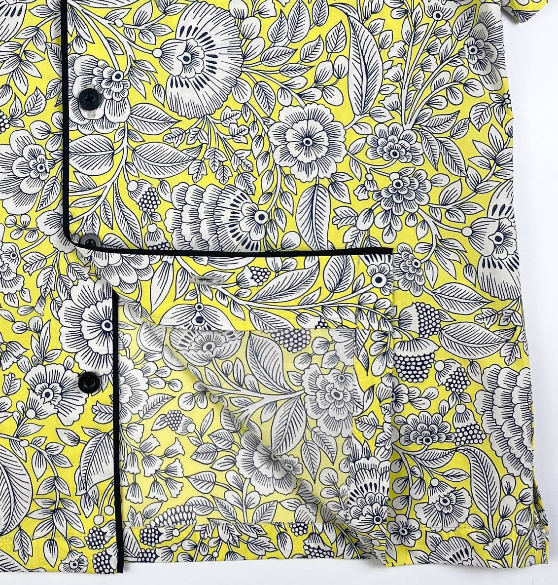 Sunshine Chintz short sleeve pyjama top lay flat showing inside seam detail, yellow cotton with grey floral print with black contrast piping. Saigon Concepts