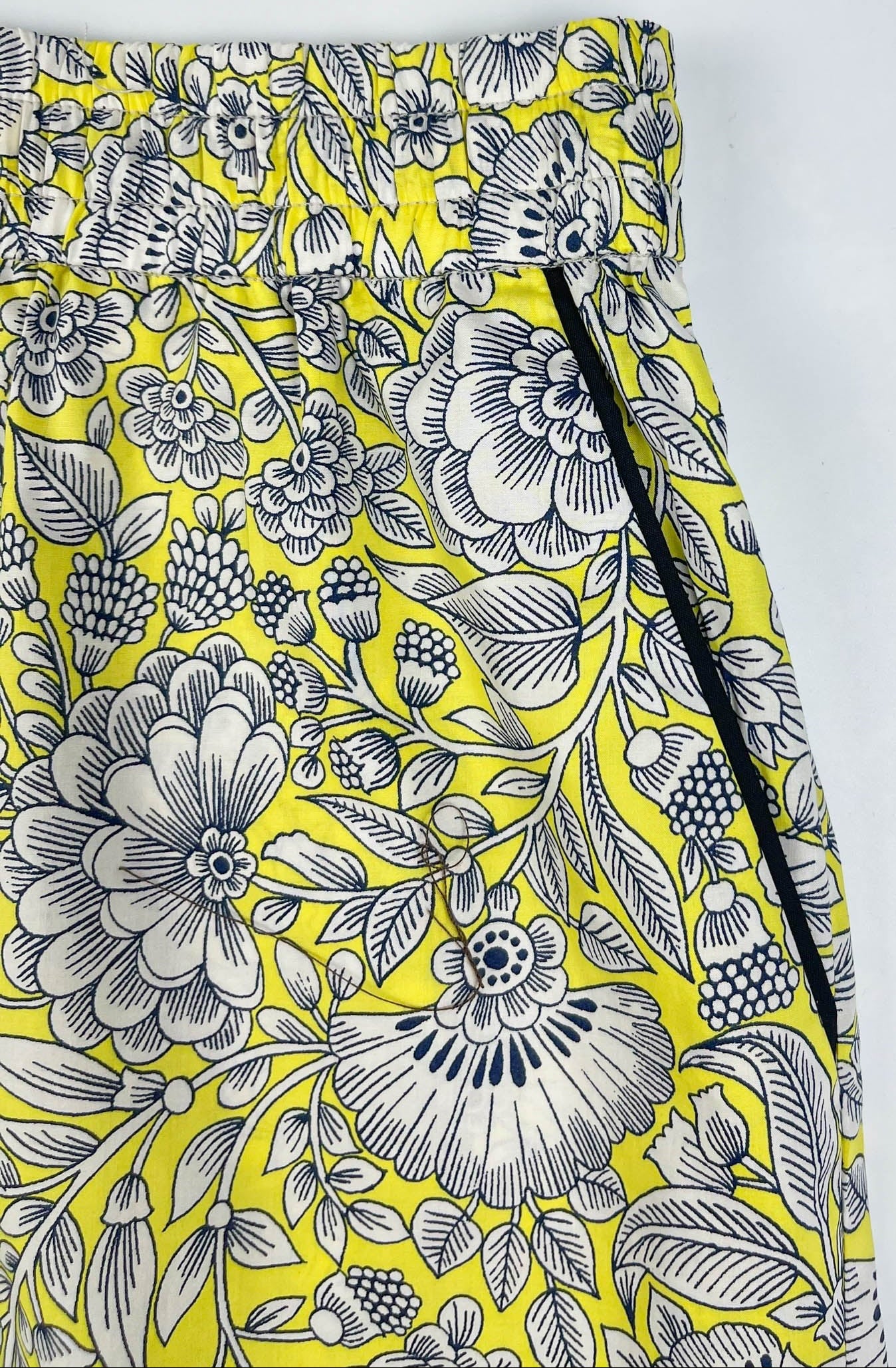 Sunshine Chintz pyjama shorts lay flat close up of elasticated waistband and black contrast piping on pocket. Yellow cotton with grey floral print - Saigon Concepts