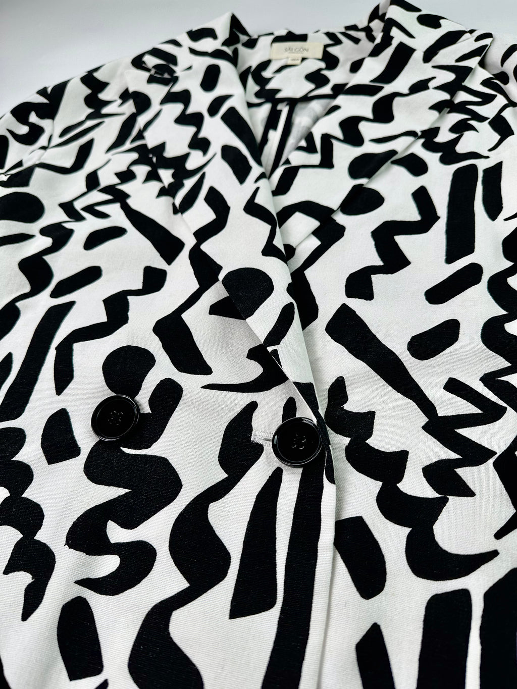 Saigon Concepts Black and white Urban Canvas patterned jacket on a light grey background - front button detail view