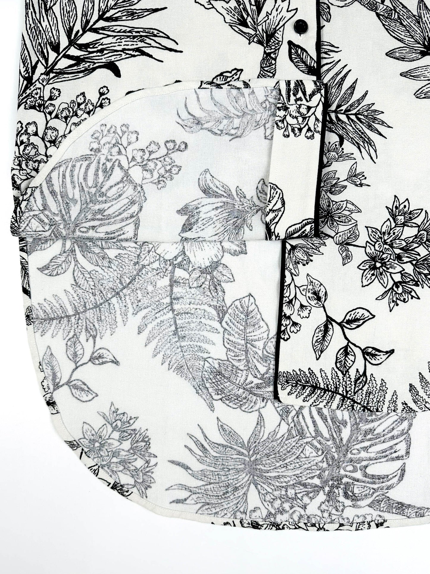 Saigon Concepts Botanical Noir Longline PJ Top with black floral etched drawing on white linen - hem detail view with contrasting black piping.