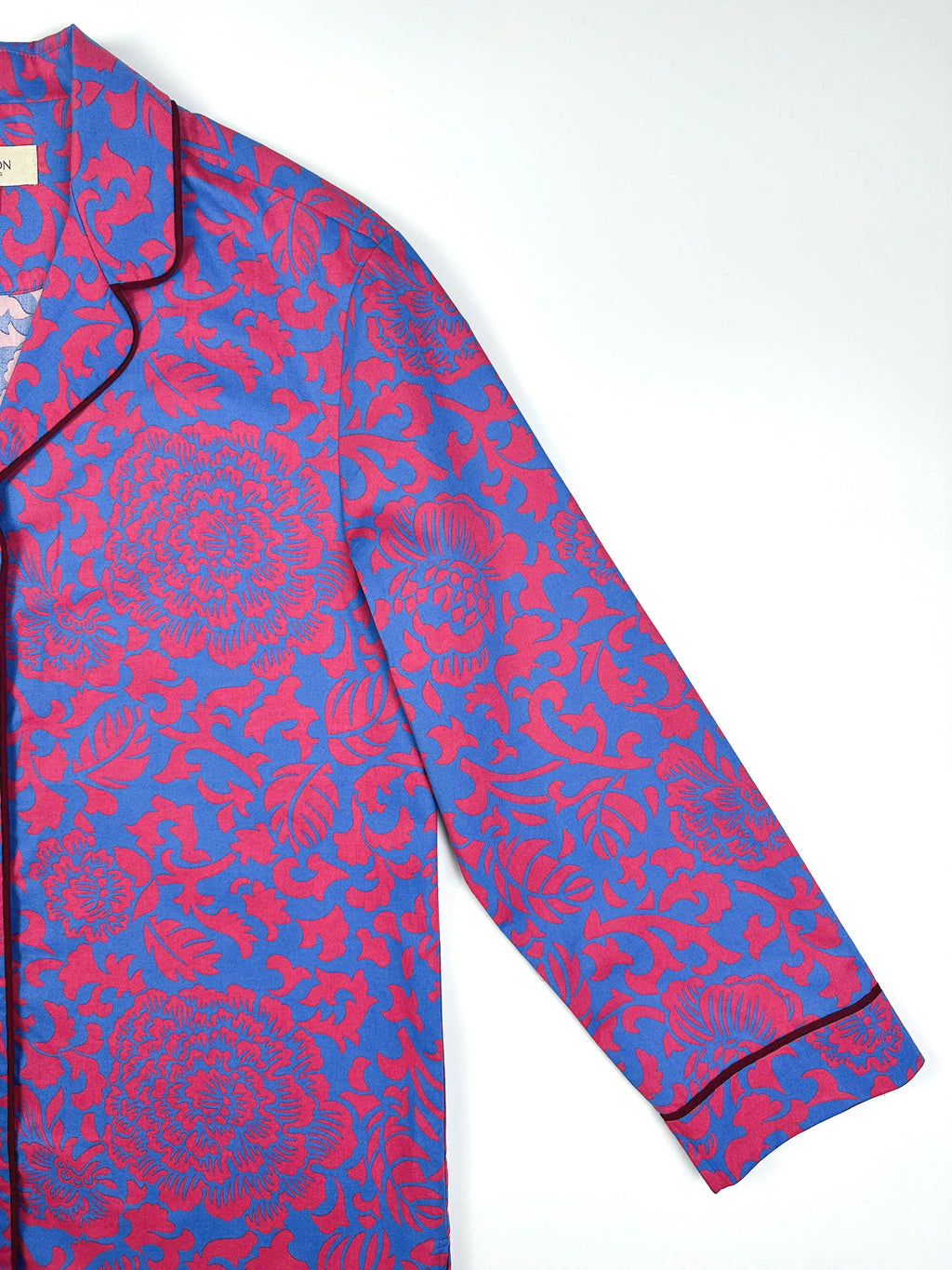 Saigon Concepts Close-up of Jardin Royale long line PJ top showing sleeve detail and contrasting dark wine piping on collar and sleeve with elegant floral print