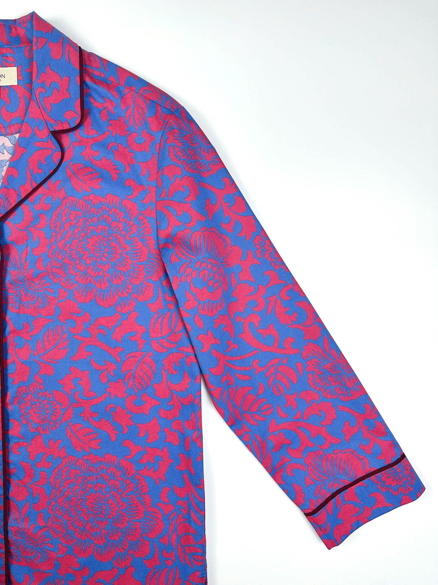 Saigon Concepts Close-up of Jardin Royale long line PJ top showing sleeve detail and contrasting dark wine piping on collar and sleeve with elegant floral print