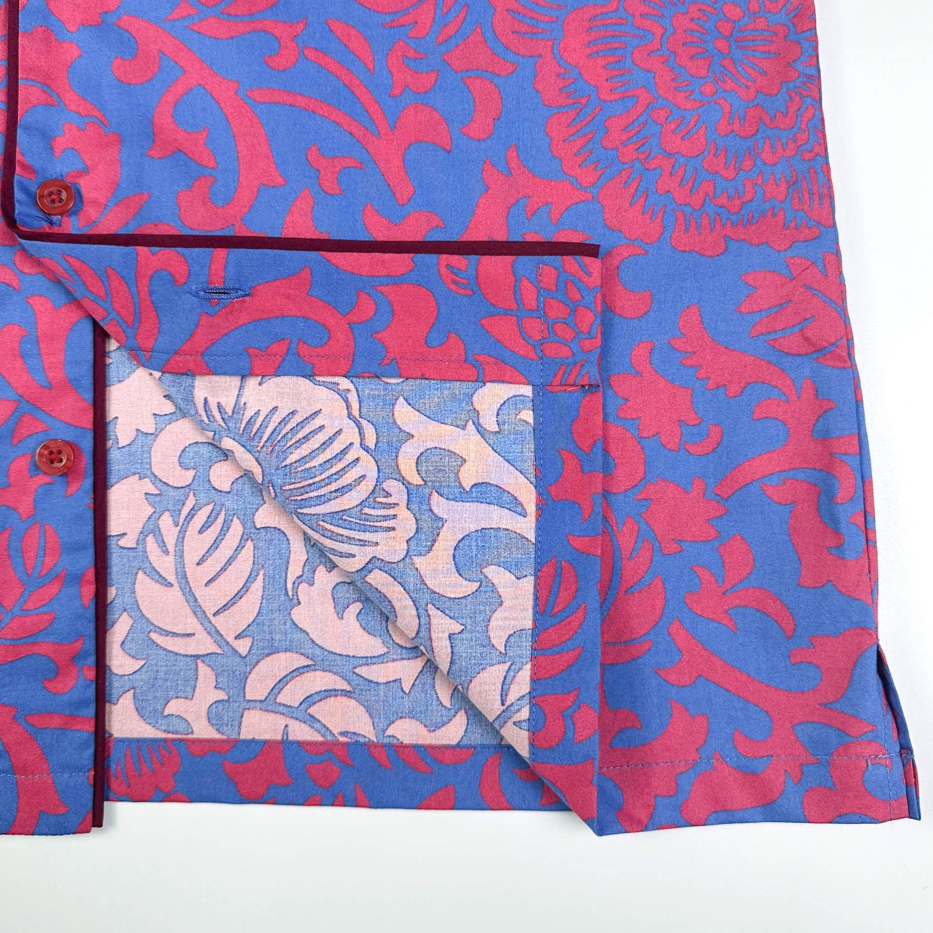 Saigon Concepts Jardin Royale lounge pyjama top in 100% cotton with red pink floral print on blue background with contrasting wine trim. Inside edge detail. Lounge to Street collection made in Vietnam