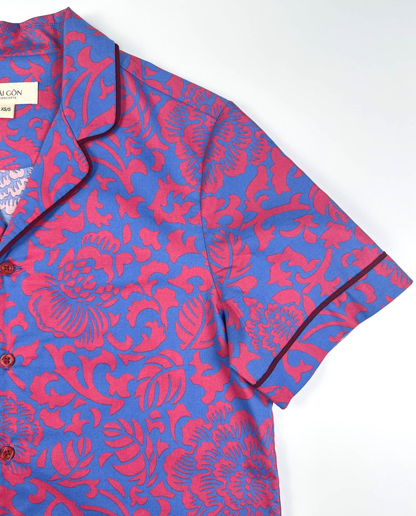 Saigon Concepts Jardin Royale lounge pyjama top in 100% cotton with red pink floral print on blue background with contrasting wine trim. Sleeve detail. Lounge to Street collection made in Vietnam