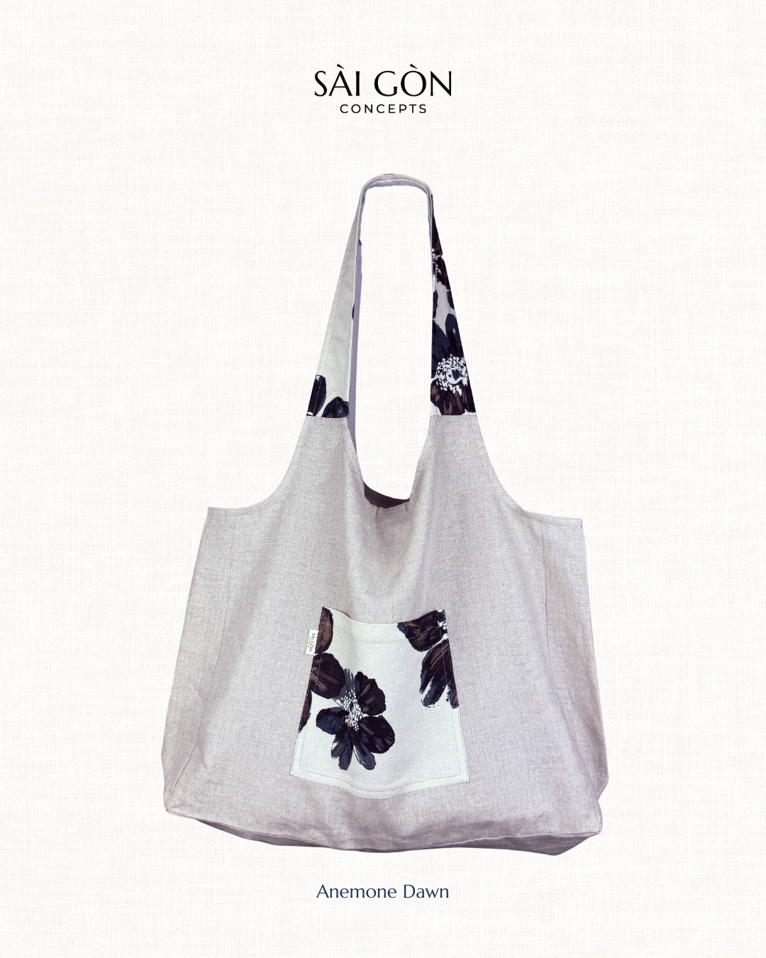 Saigon Concepts natural linen tote bag with dark navy floral hibiscus design on a white background