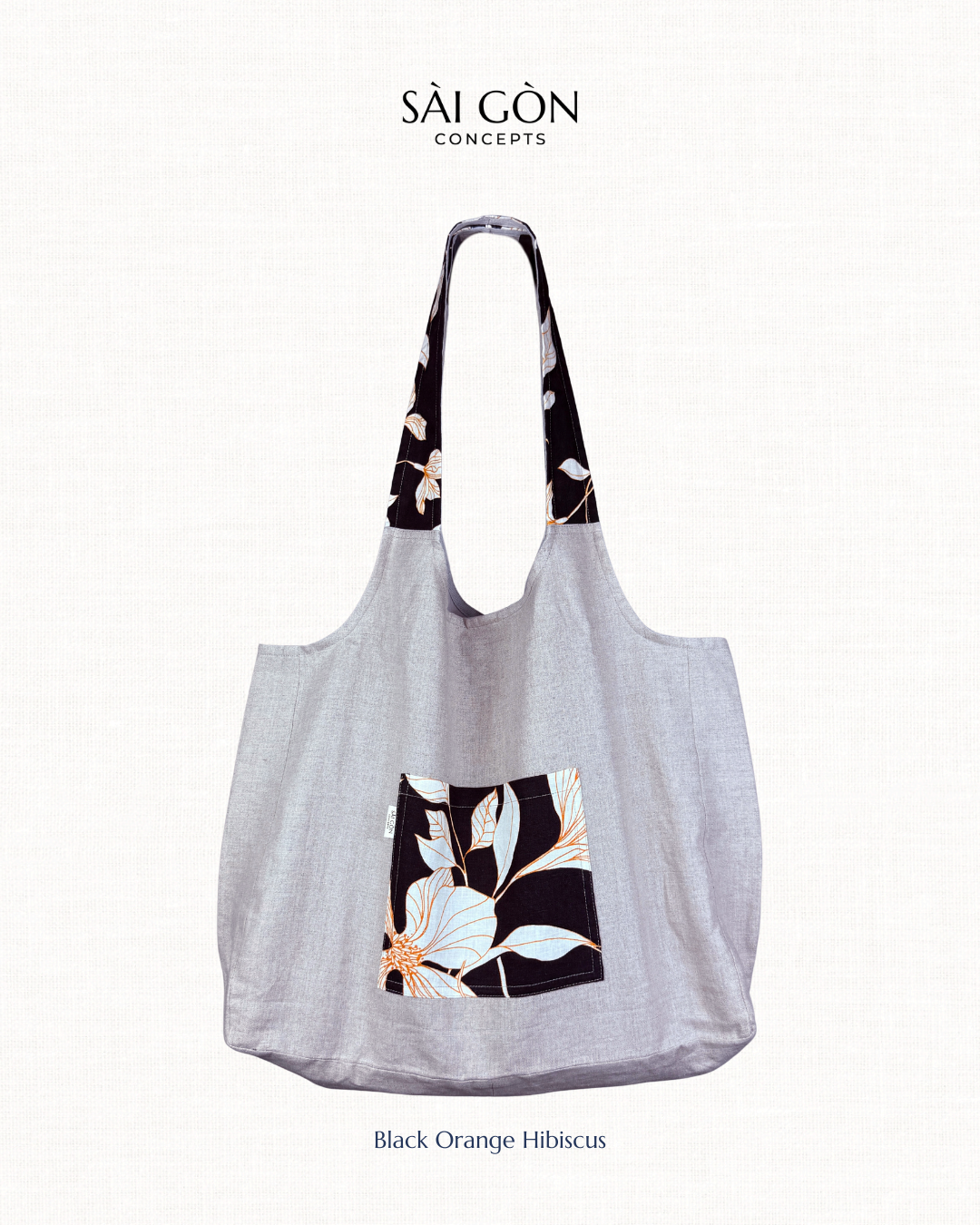 Saigon Concepts own beach tote bag with orange hibiscus floral design detail on pockets and strap, on a white background