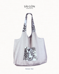 Saigon Concepts beach tote bag with Black and white botanic sketch floral contrast pocket and handle on a natural linen fabric bag