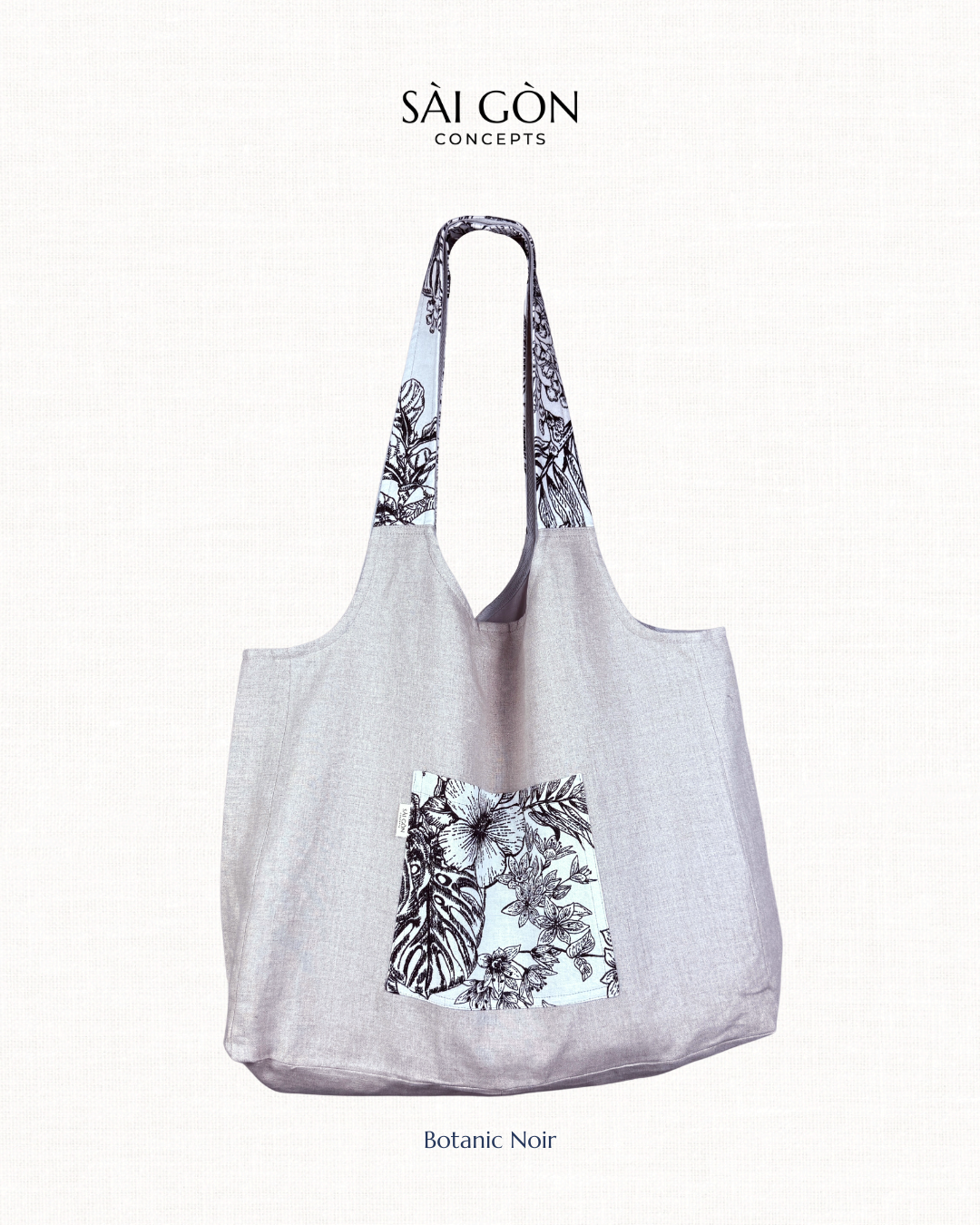 Saigon Concepts beach tote bag with Black and white botanic sketch floral contrast pocket and handle on a natural linen fabric bag