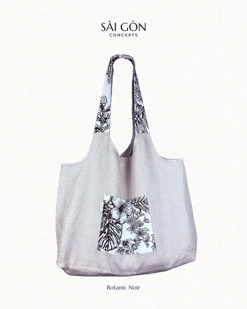 Saigon Concepts beach tote bag with Black and white botanic sketch floral contrast pocket and handle on a natural linen fabric bag