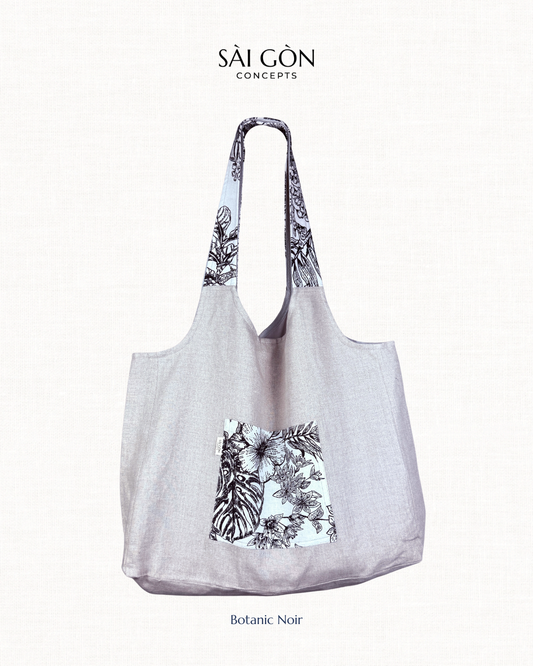 Saigon Concepts beach tote bag with Black and white botanic sketch floral contrast pocket and handle on a natural linen fabric bag