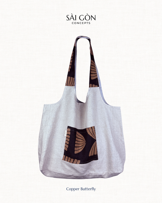 Saigon Concepts Natural Linen Beach Tote Bag with Black and Copper pocket and handle trim on a natural linen background