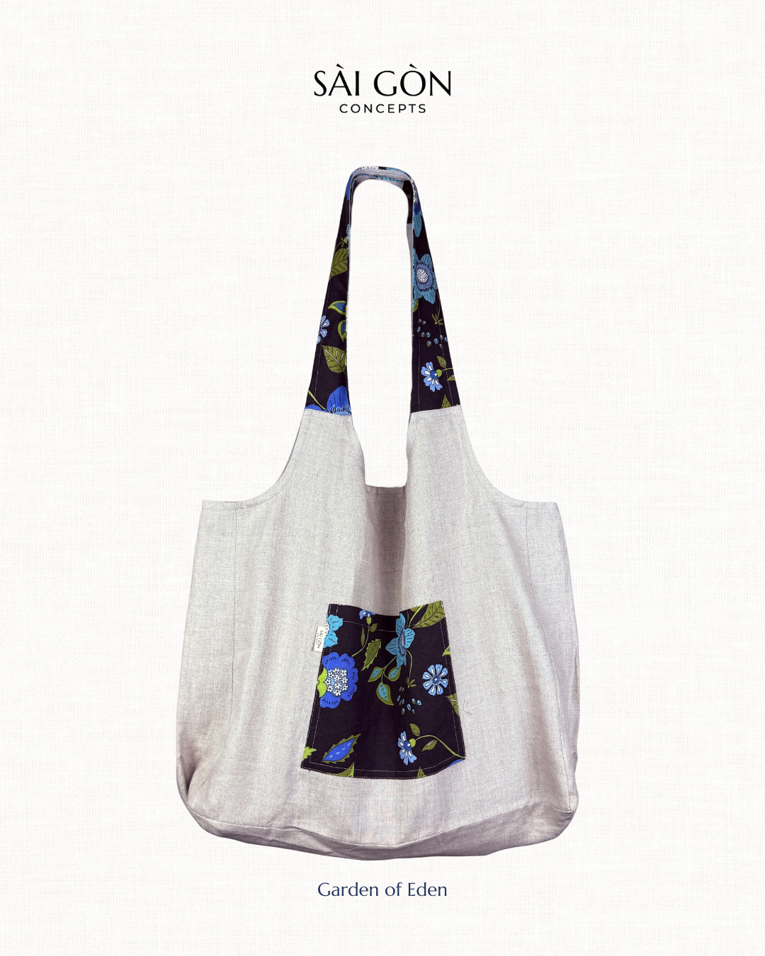 Saigon Concepts own gray beach  tote bag with floral patterned handles and pocket on a white background