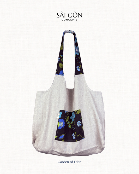 Saigon Concepts own gray beach  tote bag with floral patterned handles and pocket on a white background